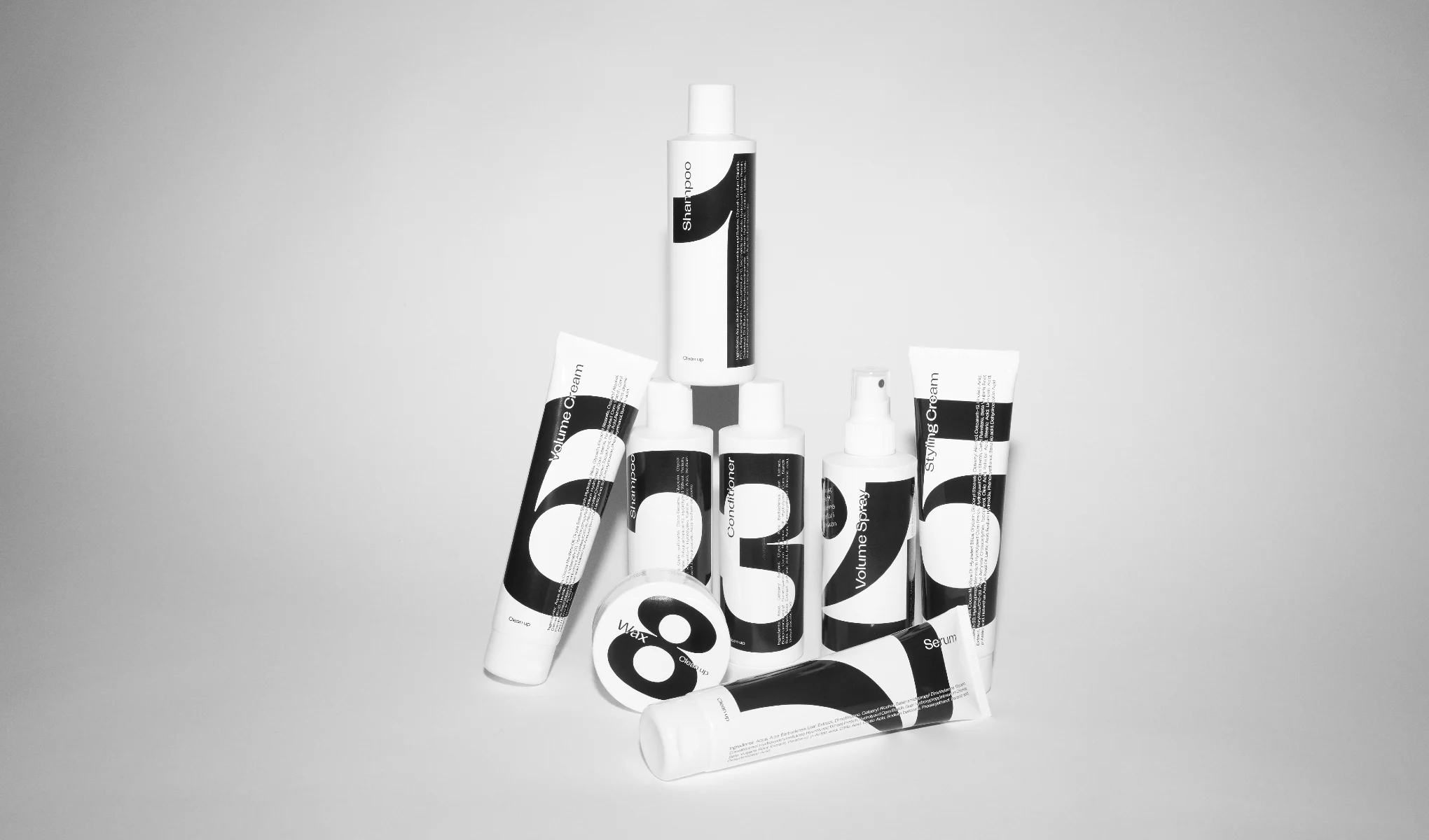 Flere hårpleieprodukter fra merket Clean 90, blant annet sjampo, balsam, volumspray, stylingkrem, volumkrem, voks og serum. Produktene har et minimalistisk design med svart og hvit merking.