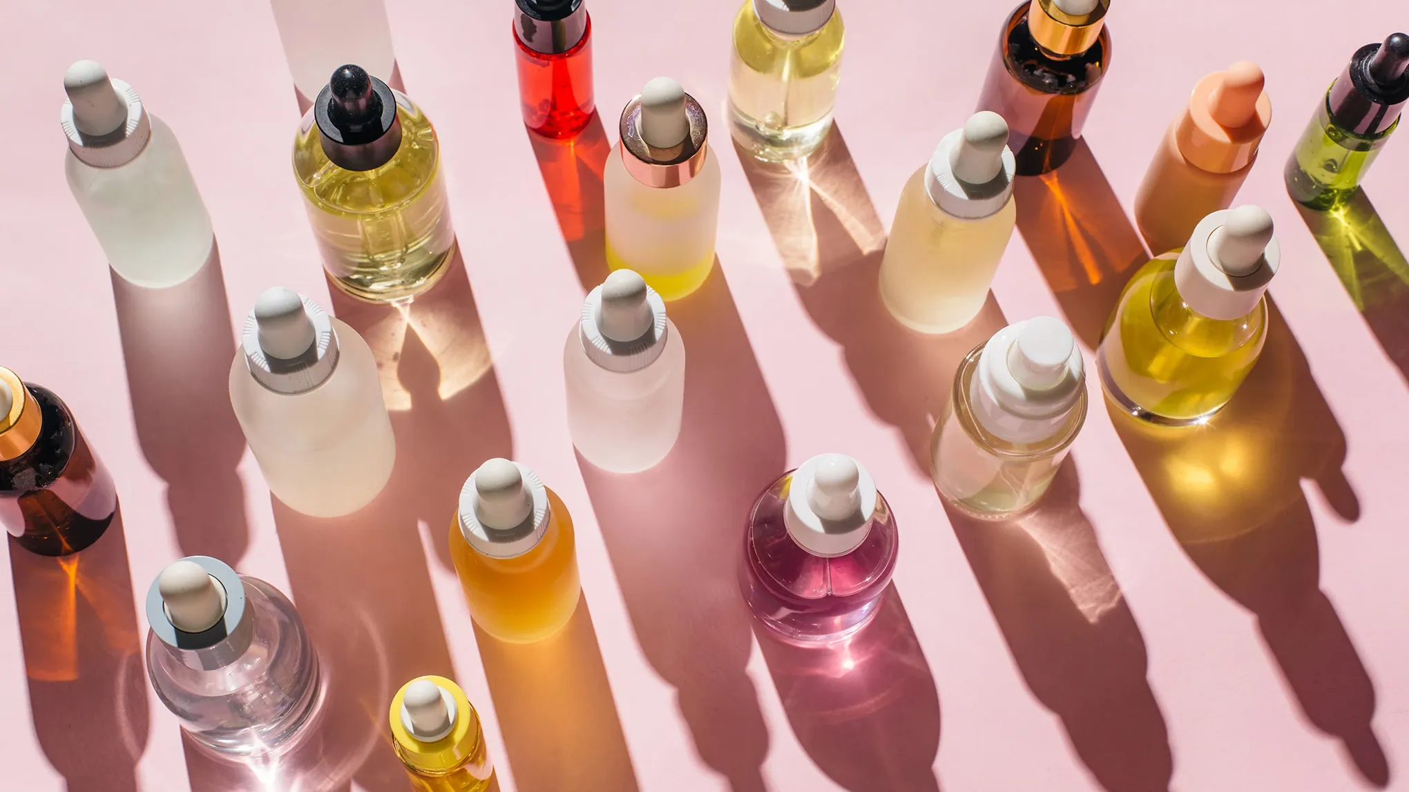Flera hudvårdprodukter på en rosa yta.