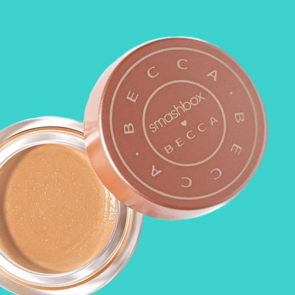 Smashbox x Becca -peitevoide. Avoin purkki, jossa näkyy beige peitevoide ja ruskea kansi turkoosilla taustalla.