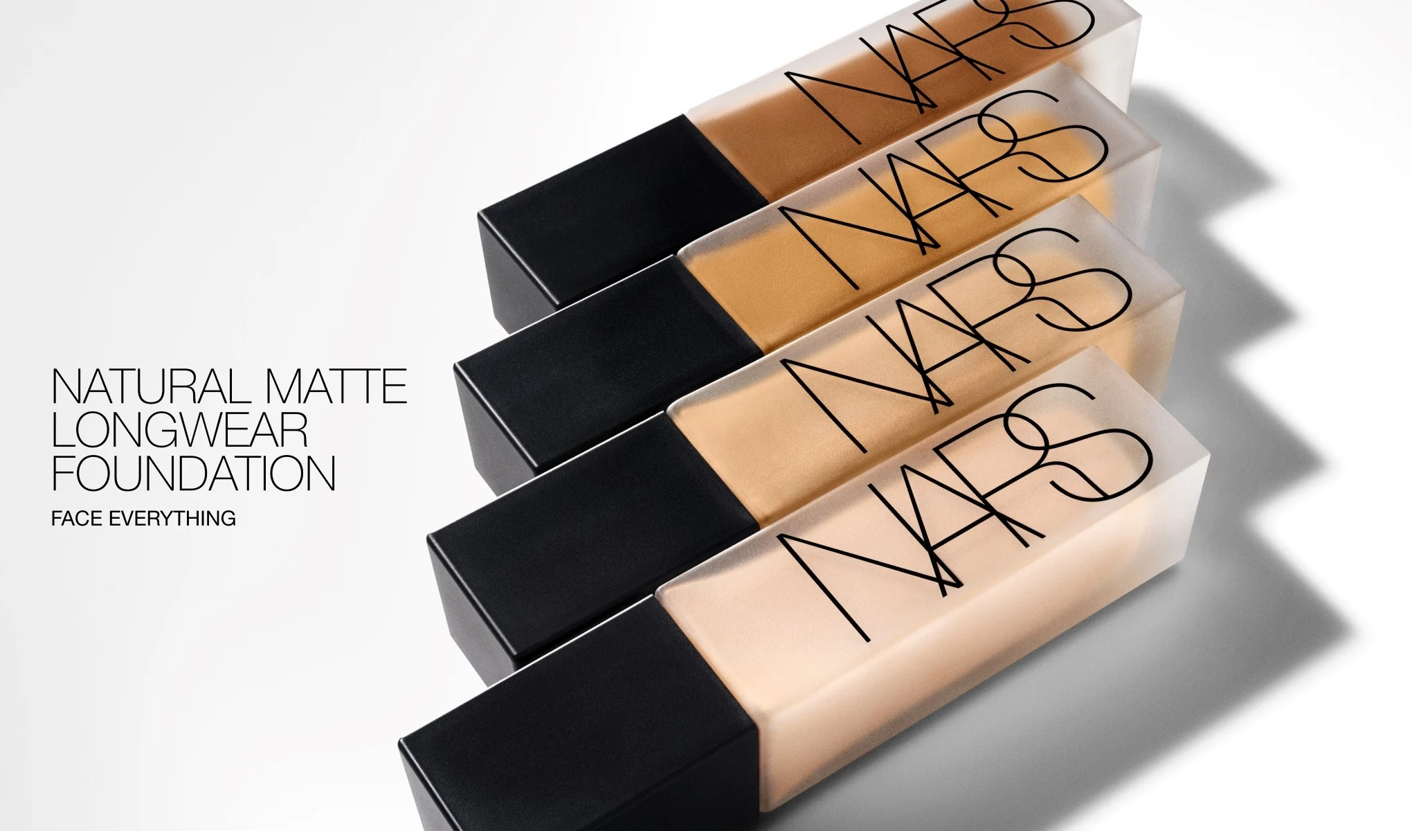 Fire foundationflasker fra NARS med svart kork og teksten “NARS”. Til venstre vises teksten “NATURAL MATTE LONGWEAR FOUNDATION” og “FACE EVERYTHING”, og flaskene viser ulike nyanser av flytende foundation.