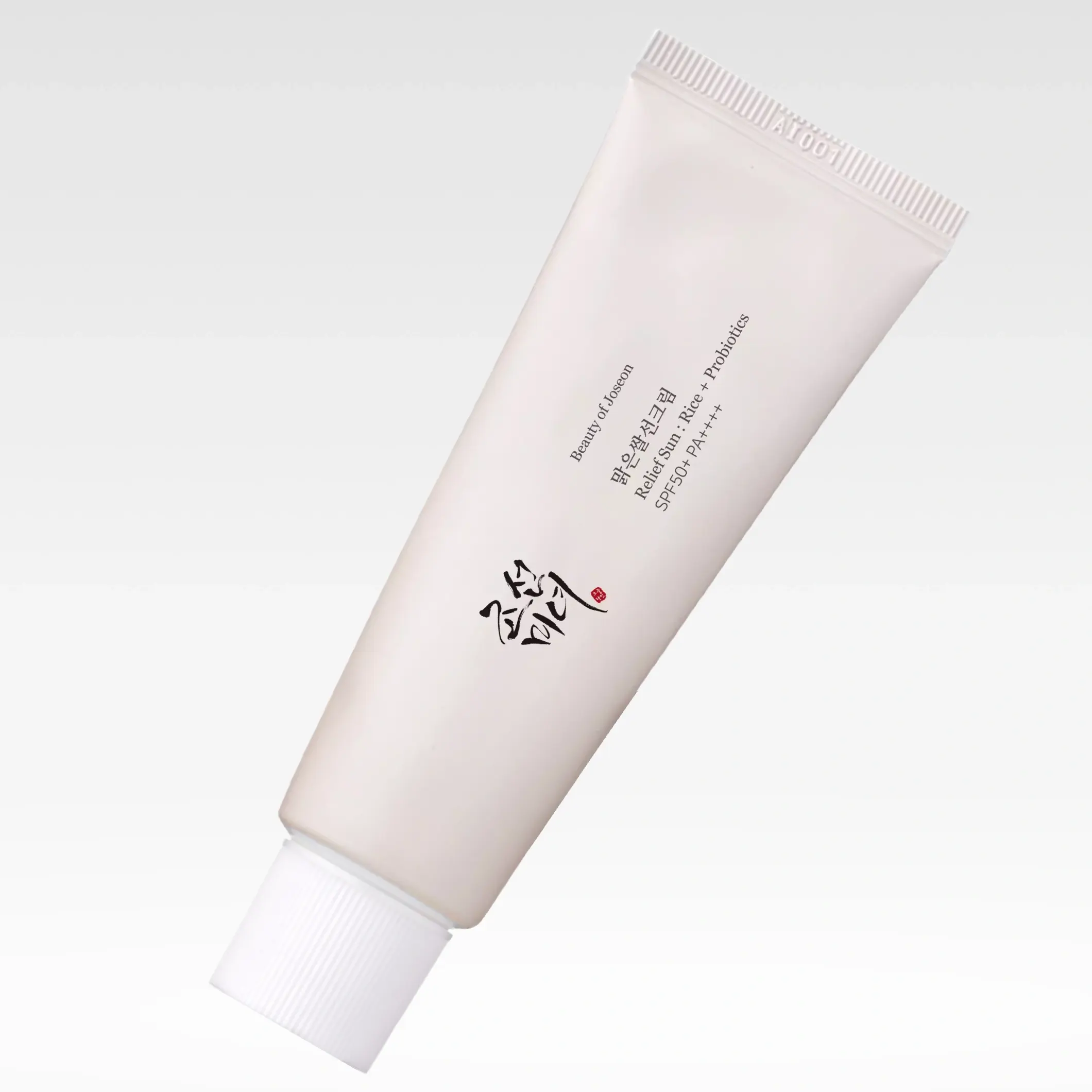 Kasvojen aurinkosuojavoide tuubissa, Beauty of Joseon Relief Sun SPF50+ PA++++, valkoinen pakkaus mustalla tekstillä vaaleaa taustaa vasten.