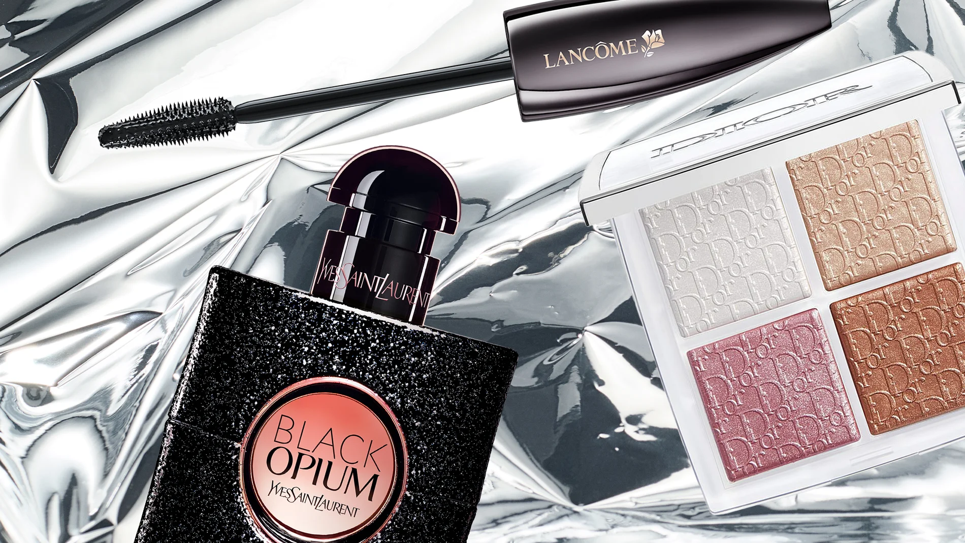 En eksklusiv beauty flatlay med Lancôme-mascara, YSL Black Opium-parfyme og en Dior-palett med skimrende øyenskygger i rosa, gull og beige nyanser på en blank, metallisk bakgrunn.