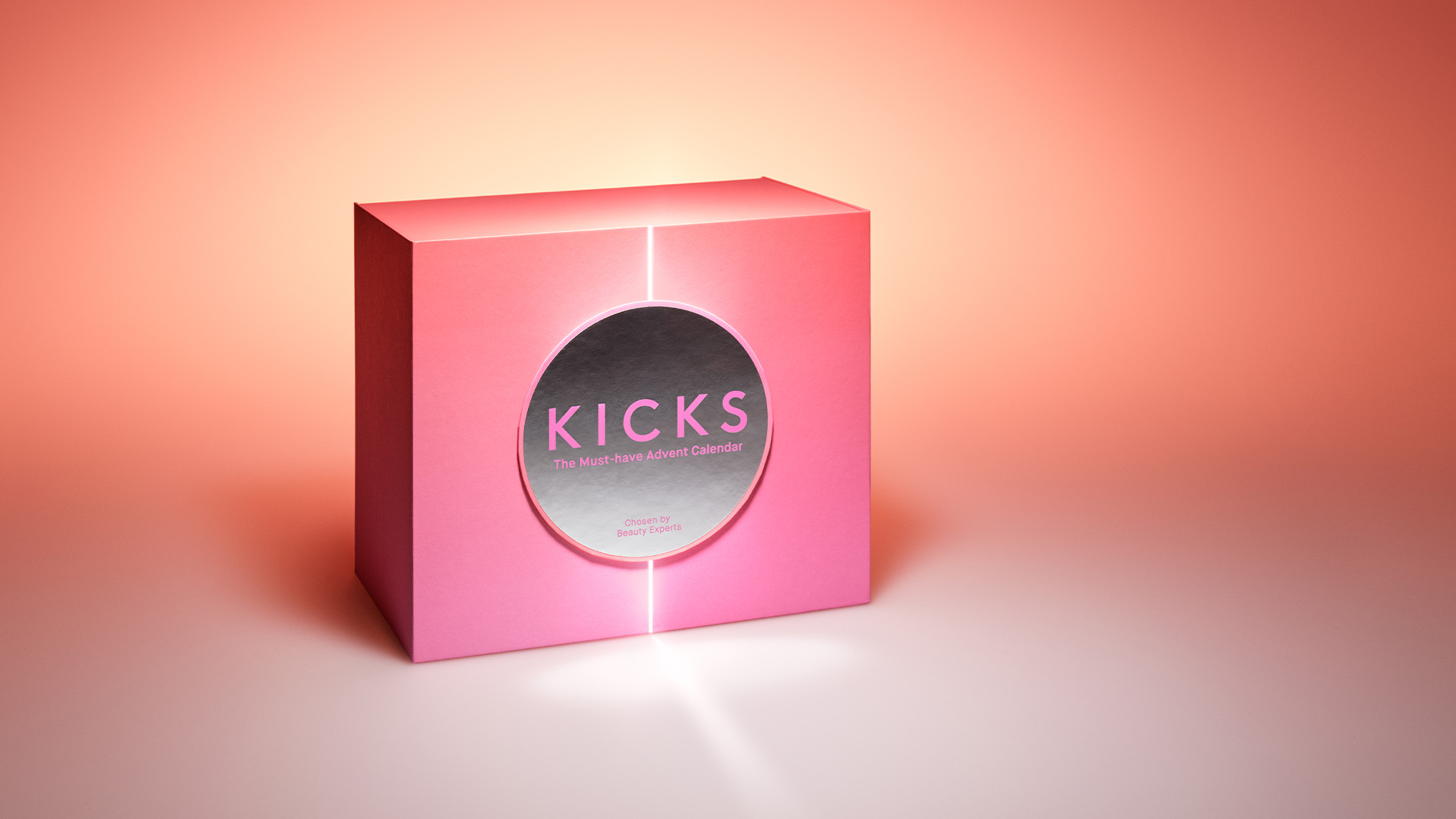 En rosa, lysande låda med Kicks-logga på framsidan, mot en bakgrund som tonas från vitt till orange.