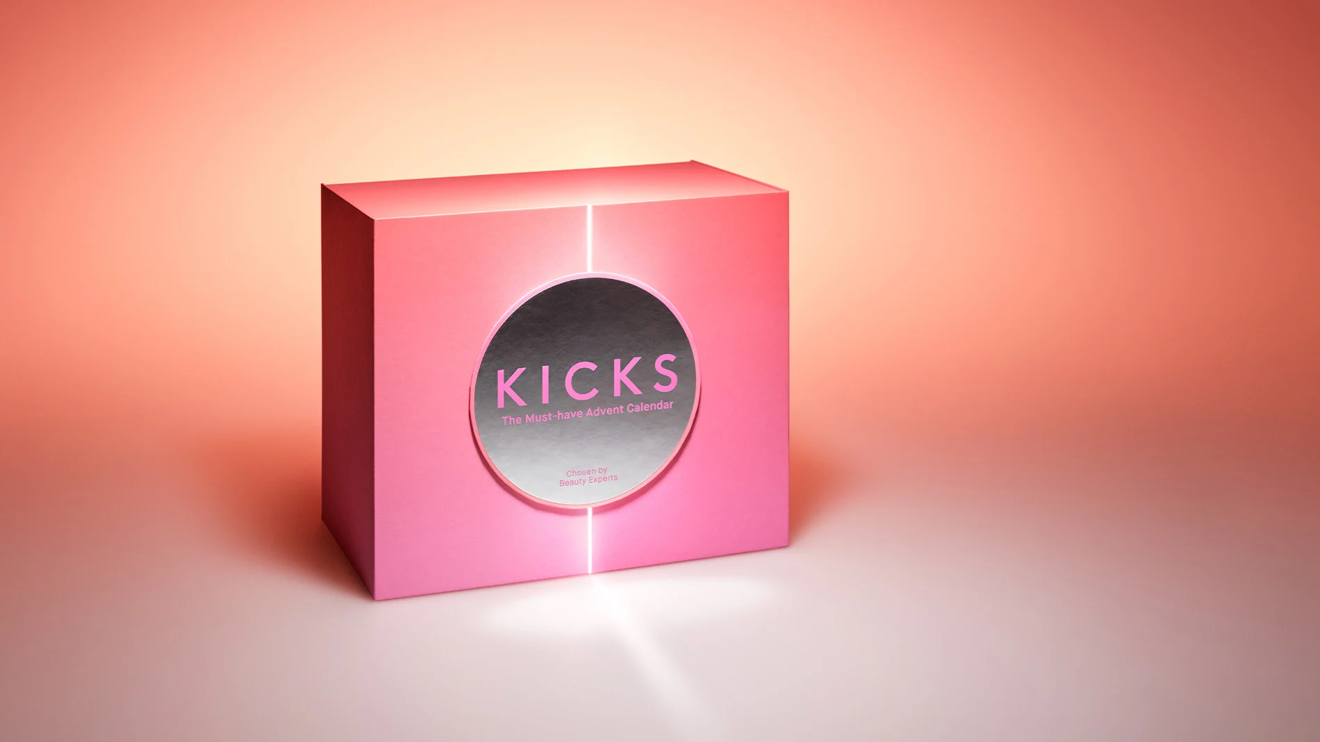 En rosa, lysande låda med Kicks-logga på framsidan, mot en bakgrund som tonas från vitt till orange.