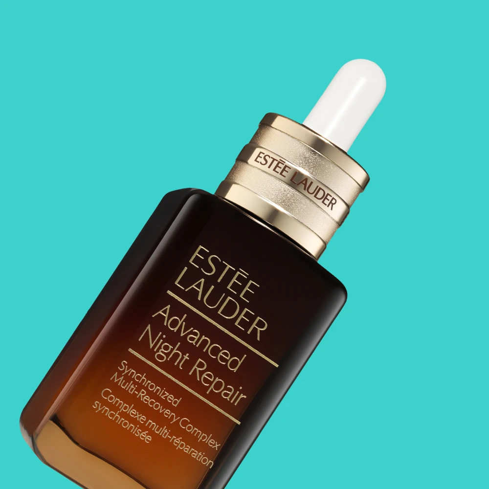 Estée Lauder Advanced Night Repair -yöseerumi. Tumma ruskea pullo kultaisella korkilla ja pipetillä turkoosilla taustalla.