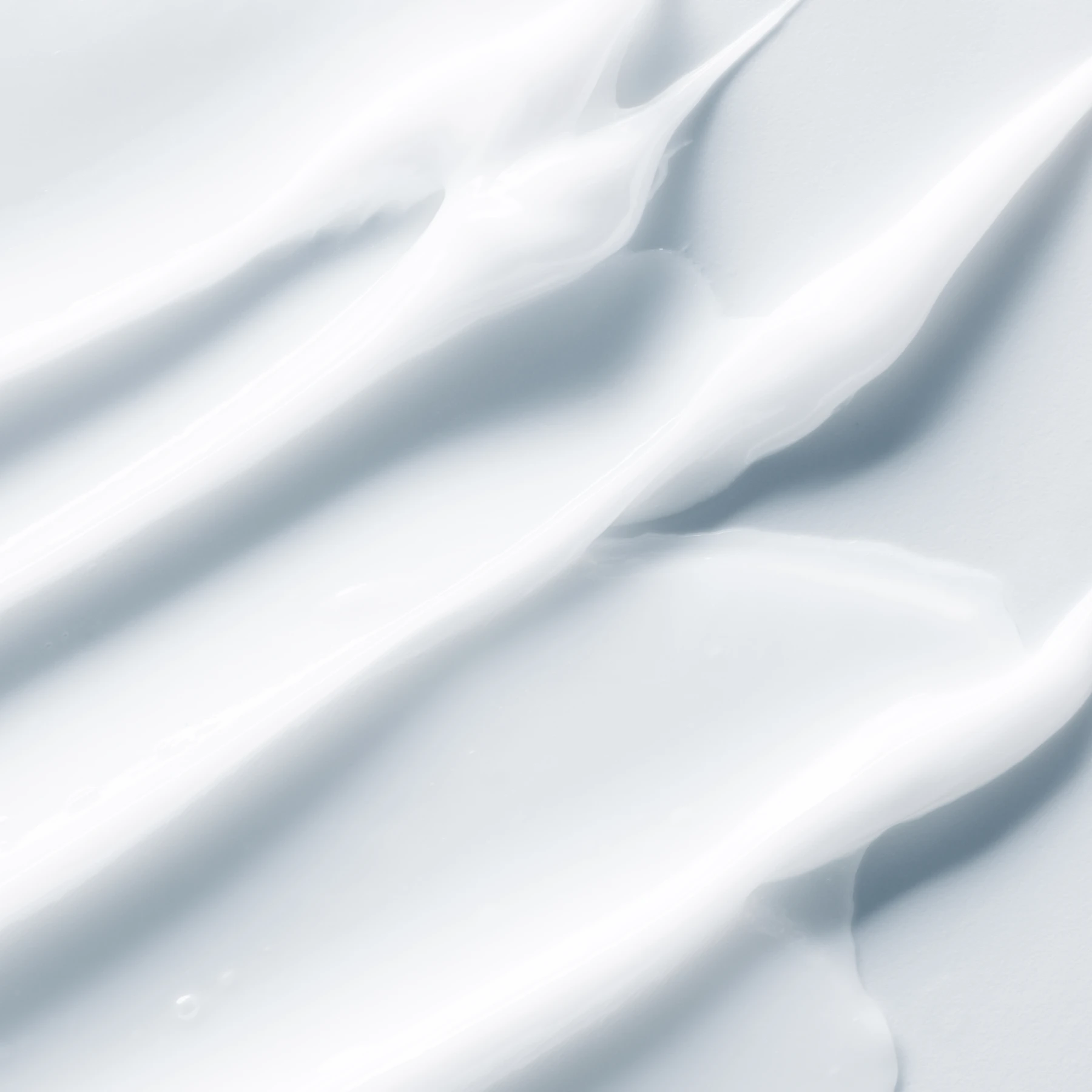  Nærbilde av teksturen til en hvit krem eller gel.