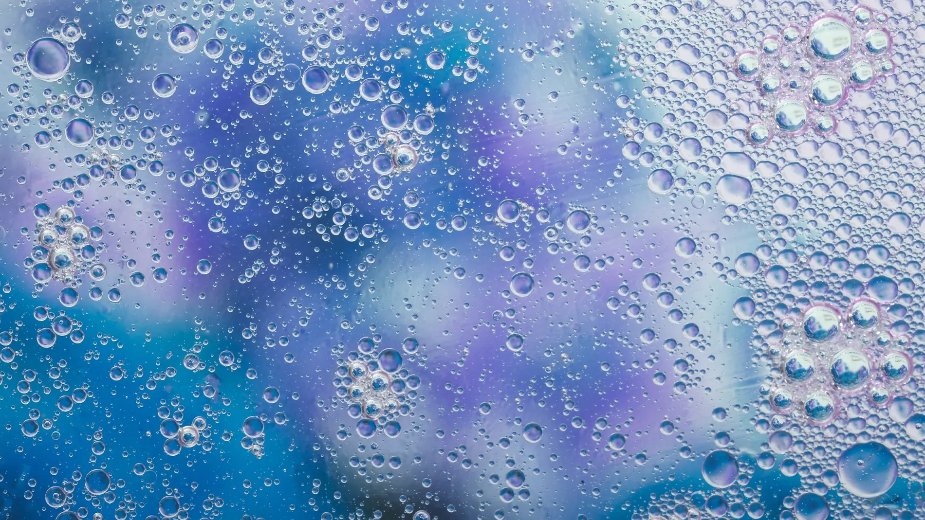 Vesihelmiä sinisellä ja violetilla taustalla.