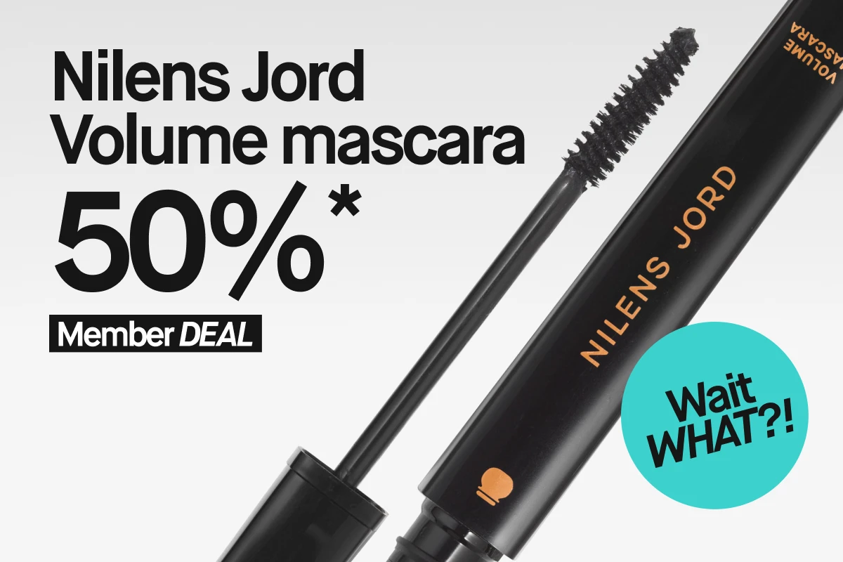 Kampanjegrafikk med teksten “Nilens Jord mascara 50%* Member DEAL” og en turkis sirkel med “Wait WHAT?!”, ved siden av en åpen Nilens Jord-maskara.