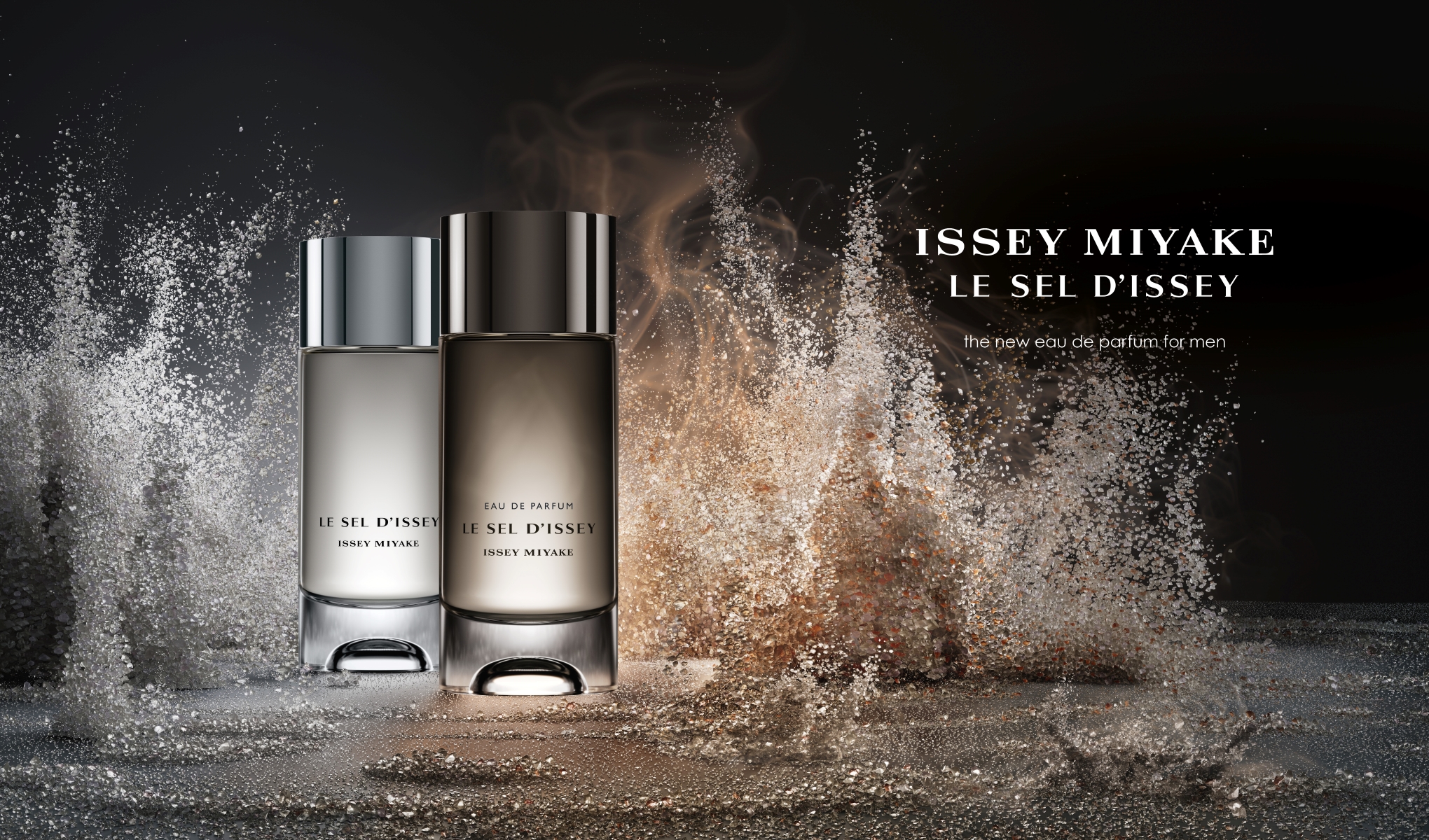 Kaksi Issey Miyake -hajuvesipulloa, joissa on teksti "LE SEL D'ISSEY", seisovat tummalla taustalla. Taustalla näkyy suolahiukkasia ja teksti "the new eau de parfum for men".