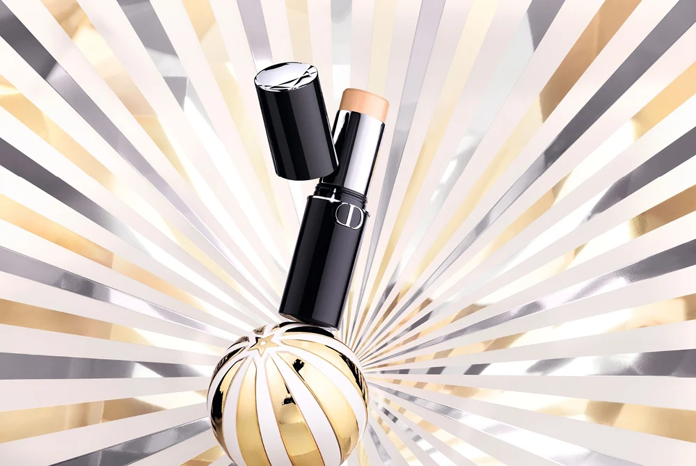 Dior Forever Skin Perfect Foundation Stick mot hvit, sølv og gyllen bakgrunn.