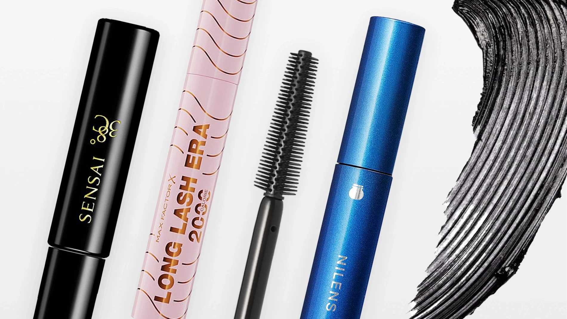 Tre mascaraer mot hvit bakgrunn: svart Sensai 38°C, rosa Max Factor X Long Lash Era 2000 Calorie og blå Sensai, sammen med en svart mascarabørste og et strøk med svart mascara.