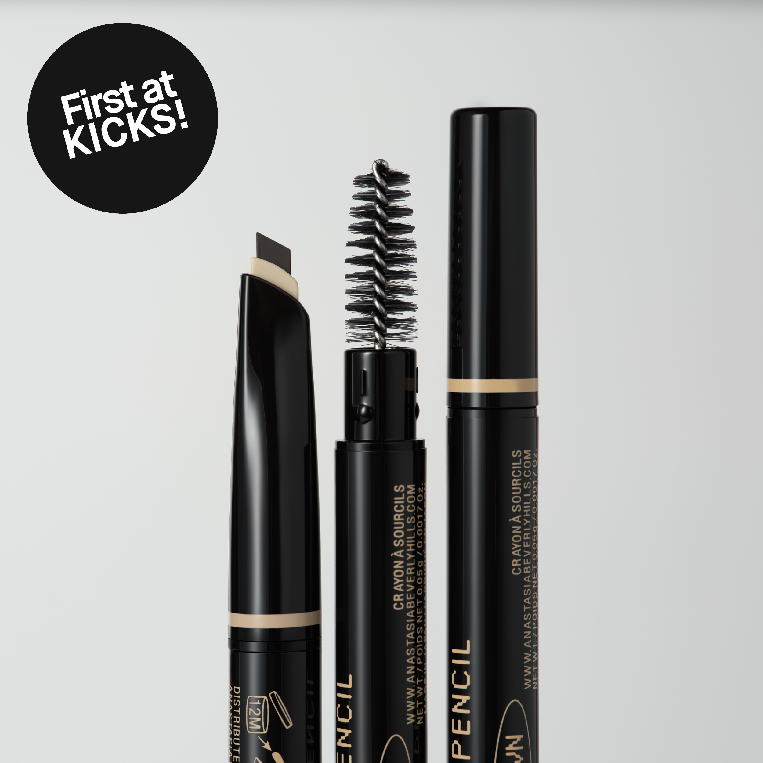 Tre svarte øyenbrynsprodukter med børste og skrå spiss mot lys bakgrunn, med teksten “First at KICKS!”.