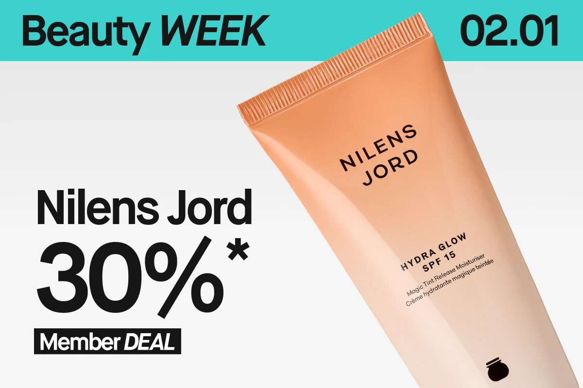 En nærbilde av Nilens Jord Hydra Glow SPF 15 i en beige tube mot lys bakgrunn. Øverst vises en turkis banner med “Beauty WEEK” og 2/1. Nederst står det “30%* Member DEAL”.