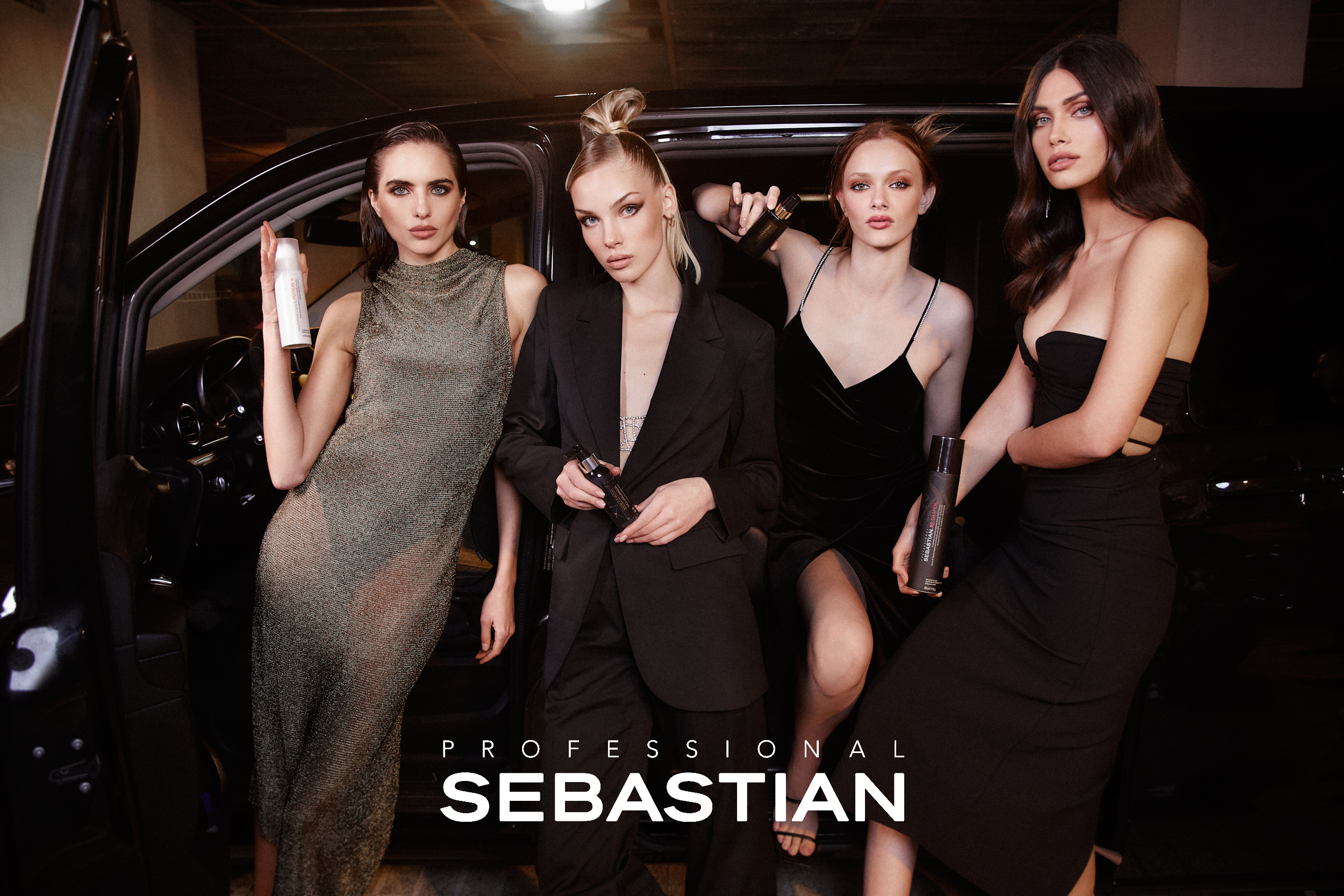 Fire personer står ved en bil med hårpleieprodukter fra Sebastian Professional i hendene. De er kledd i elegante klær. Bakgrunnen er en mørk parkeringsplass. Teksten «Professional Sebastian» er plassert nederst i bildet.