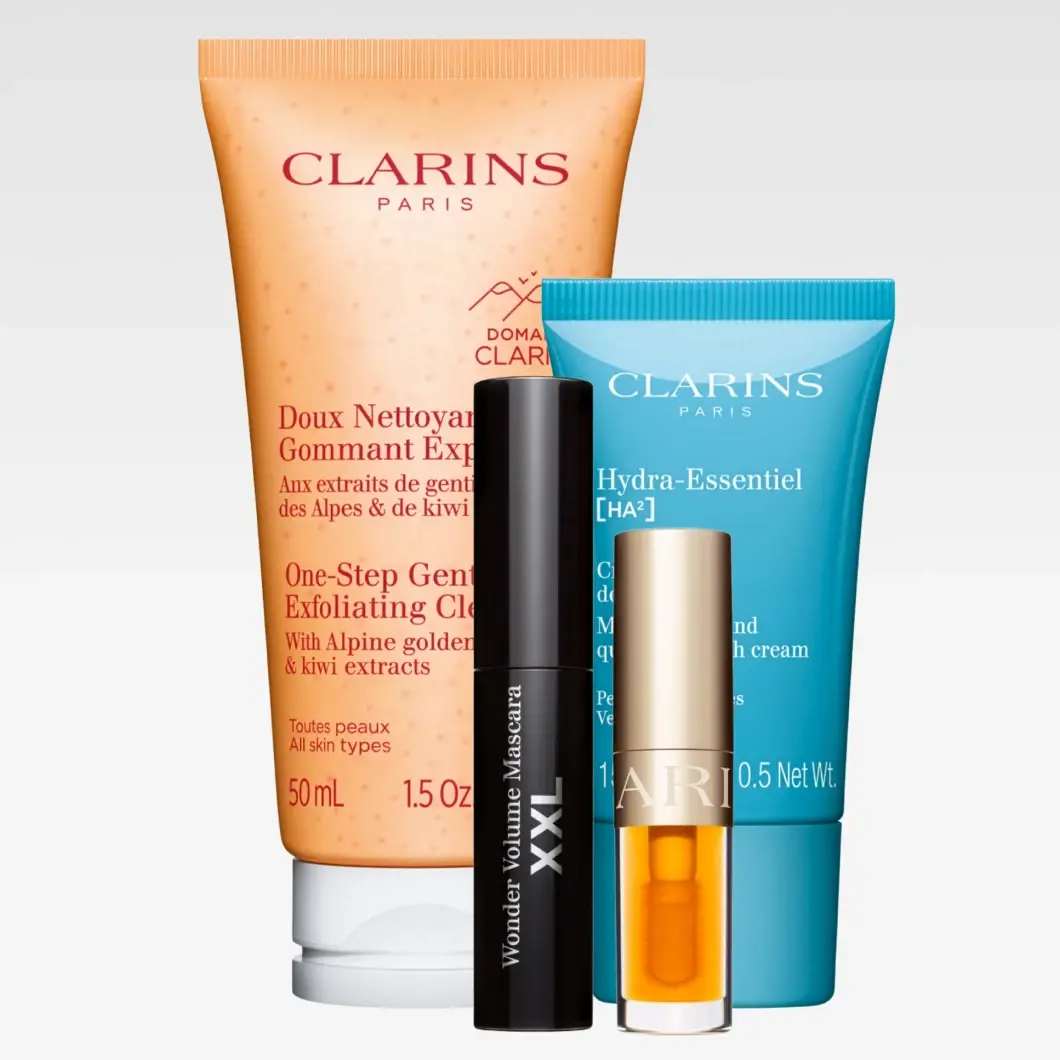 Clarins Paris hudpleie og makeup: One-Step Gentle Exfoliating Cleanser med Alpine golden gentian & kiwi extracts for alle hudtyper, 50 ml / 1.5 oz, Hydra-Essentiel [HA²] for svært tørr hud, 15 ml / 0.5 Net Wt., Wonder Volume Mascara XXL samt et lite Clarins-produkt i gullfarget emballasje.