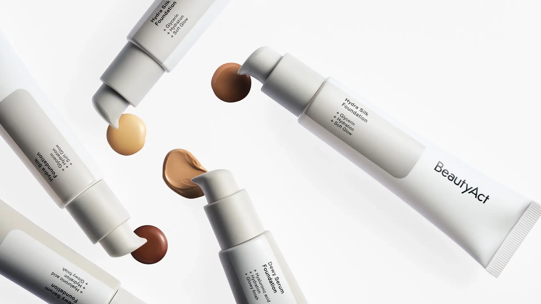 Kuva, joka näyttää erilaisia BeautyAct-meikkivoidetuotteita. Kuvassa näkyy viisi tuubia eri sävyillä meikkivoidetta, mukaan lukien vaalea, keskitumma ja tumma. Jokaisessa tuubissa on pumppu, joka vapauttaa pienen määrän meikkivoidetta. Tuotteet on aseteltu ympyrään valkoiselle taustalle.