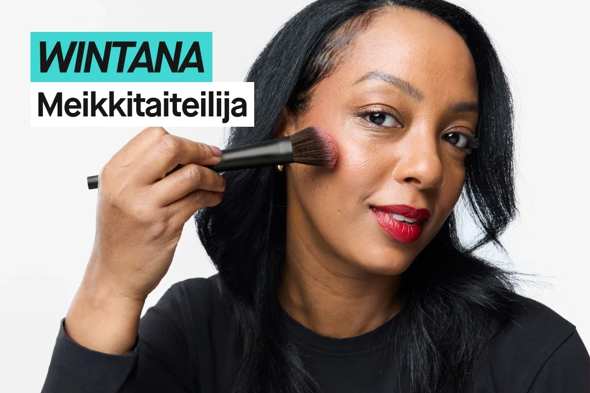 Henkilö, jolla on mustat hiukset, levittää poskipunaa meikkisiveltimellä poskelle vaaleanharmaata taustaa vasten ja käyttää mustaa KICKS-paitaa. Turkoosi ja valkoinen teksti näyttävät “WINTANA” ja “Makeupartist”.