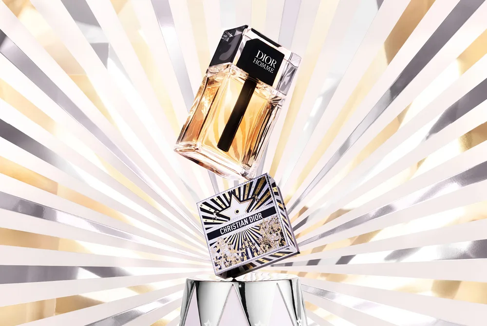 Christian Dior Homme miesten hajuvesi valkoisella, hopeisella ja kultaisella taustalla.