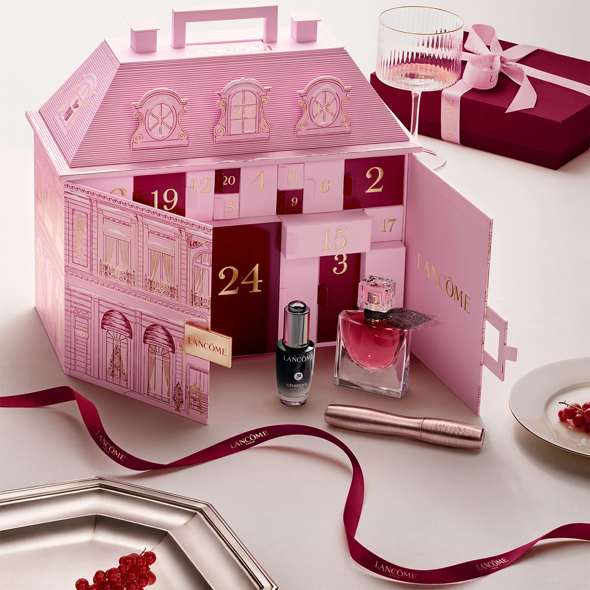Rosa husformet Lancôme adventskalender med Génifique-serum, parfyme og mascara.