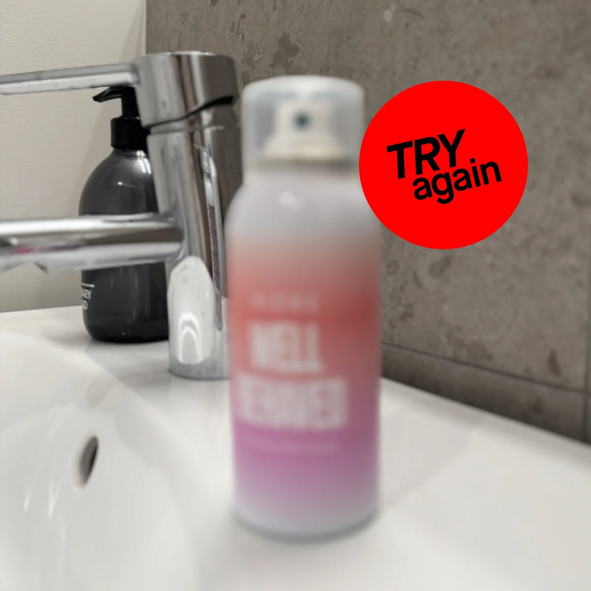 Epäselvä kuva suihkepullosta kylpyhuoneessa, jossa on teksti "TRY again" punaisessa ympyrässä.