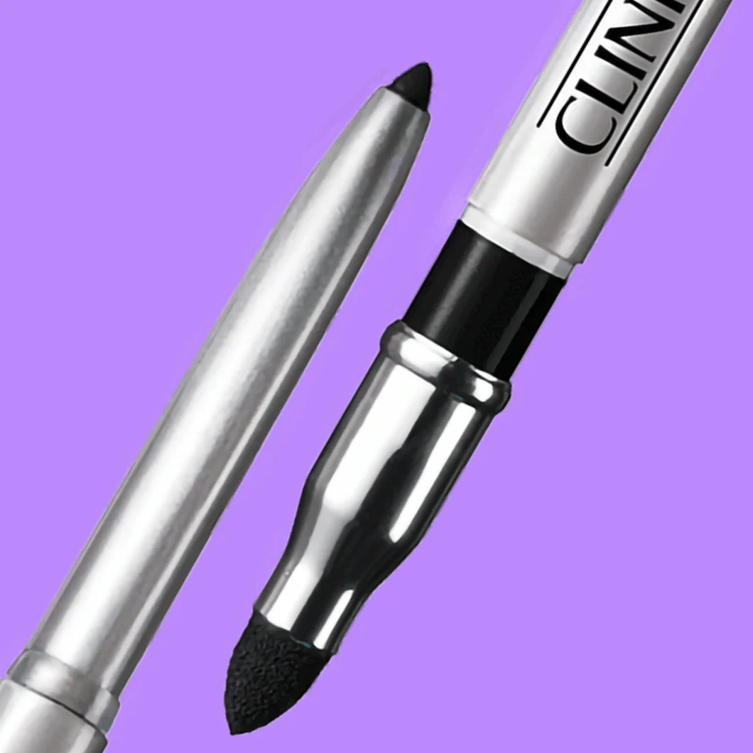 Clinique-silmämeikkikynä, jossa on musta kärki ja hopeanvärinen runko, sekä musta applikaattori violetilla taustalla. Tuotteessa näkyy teksti ”CLINIQUE”.