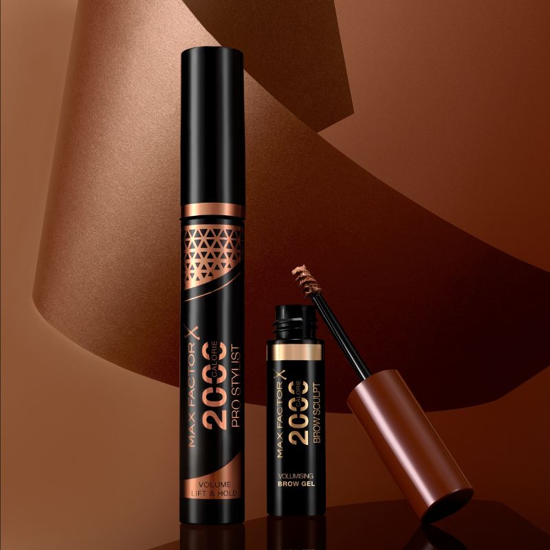 Kaksi Max Factor -meikkituotetta kuparinväristä taustaa vasten.