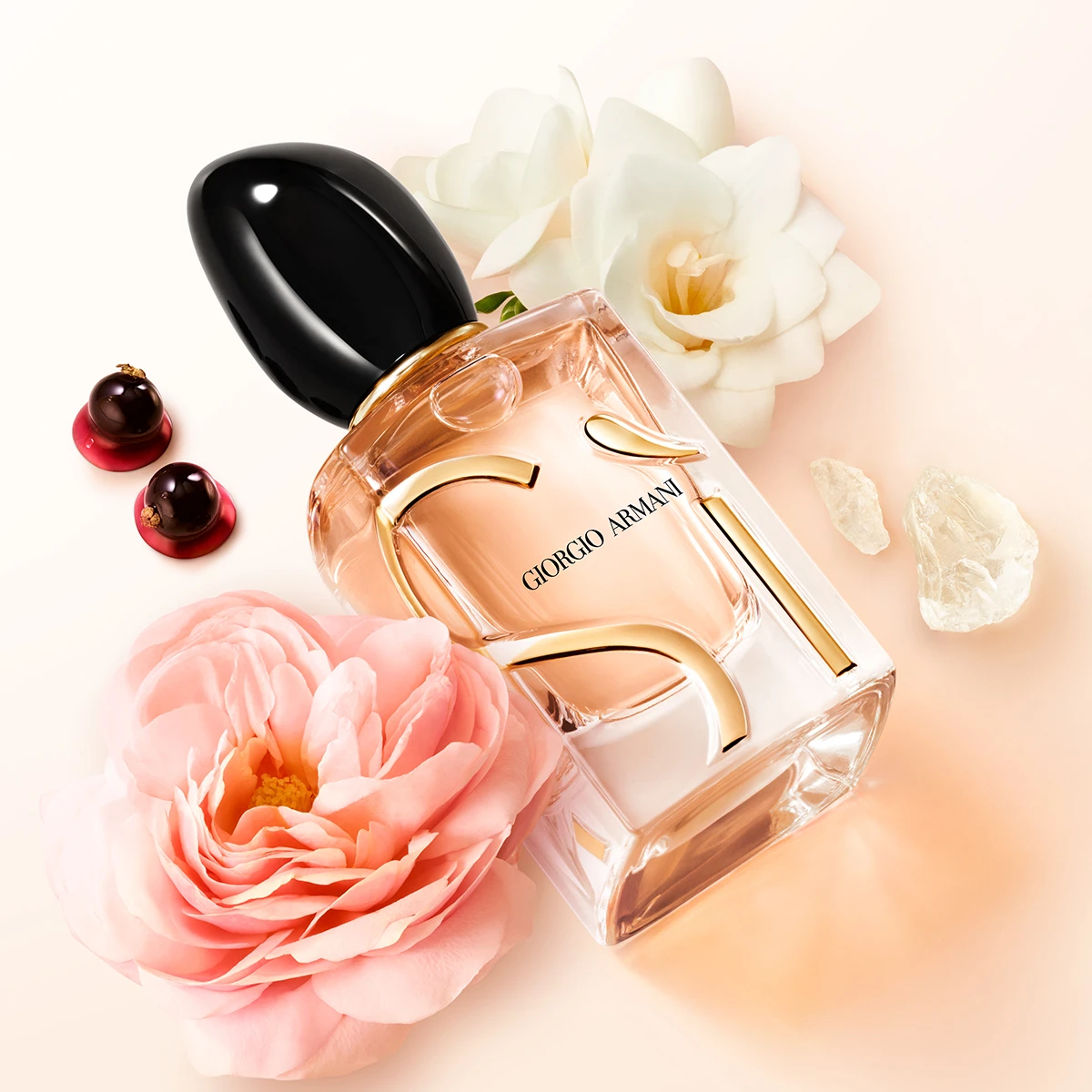 Giorgio Armani Sì parfymeflaske på lys bakgrunn med blomster, bær og krystallaktige detaljer.