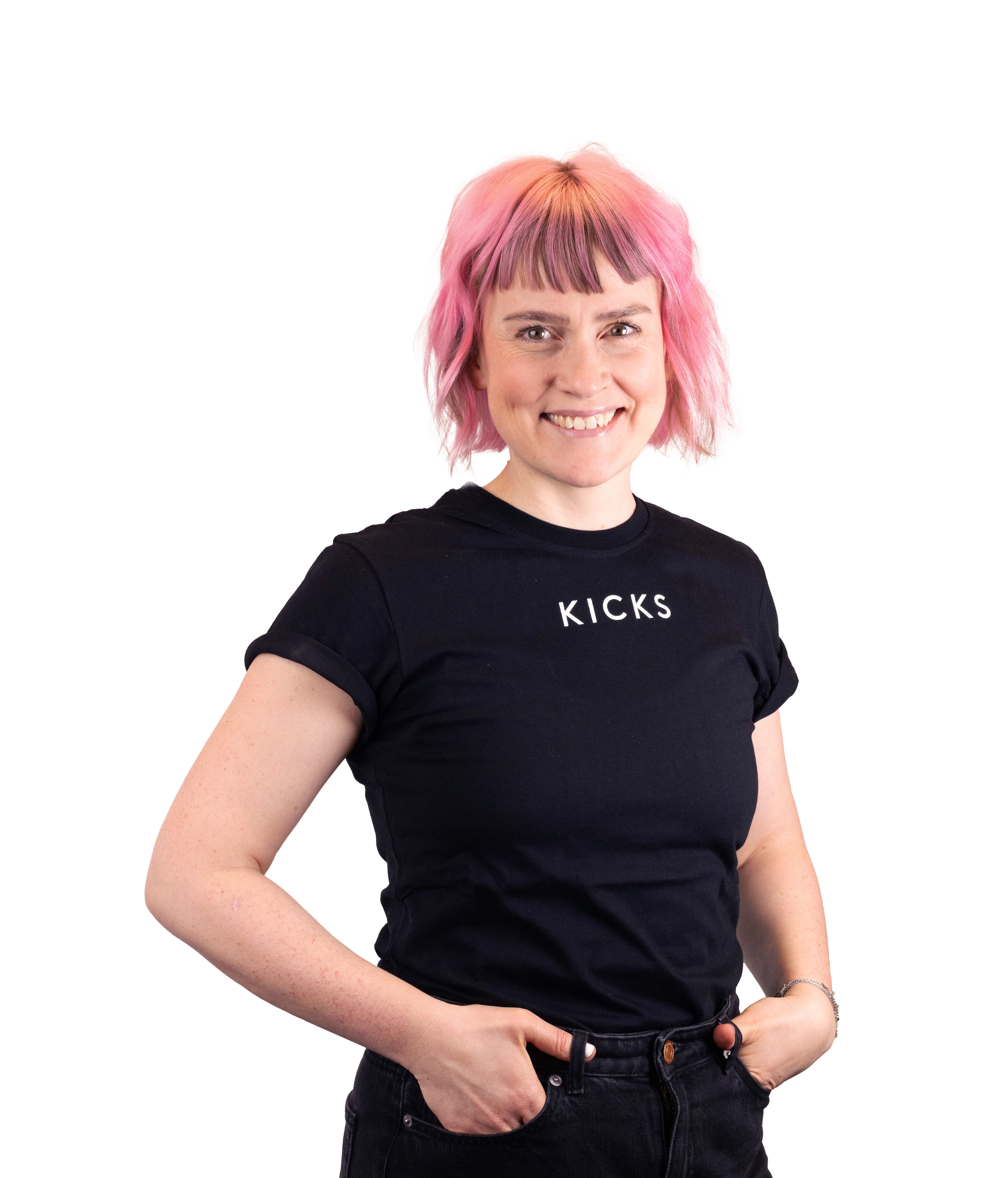 Henkilö, jolla on vaaleanpunaiset hiukset ja musta t-paita, jossa lukee "KICKS".