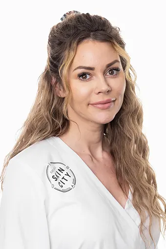Kvinna med långt, brunt och lockigt hår som delvis är uppsatt