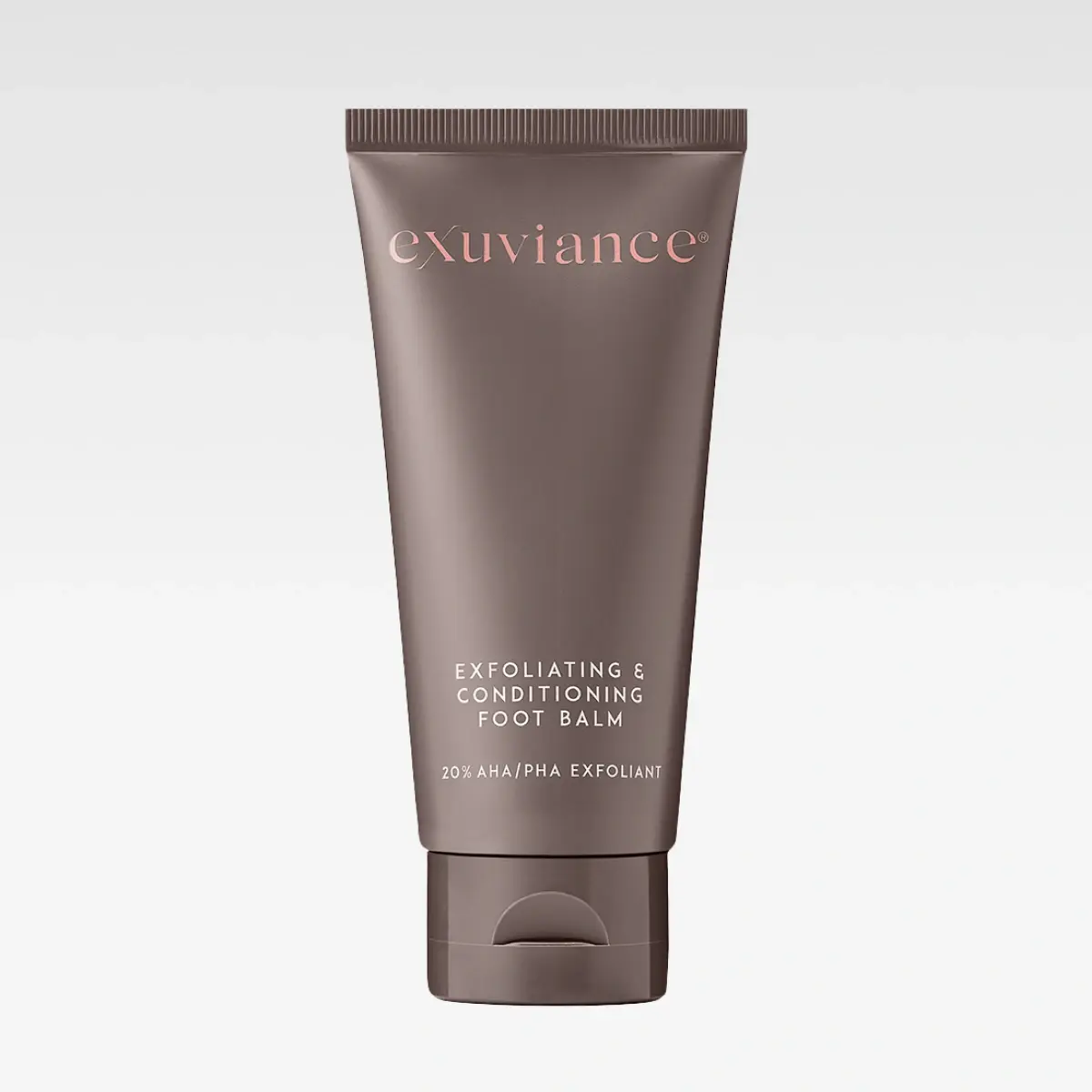 Ruskea tuubi Exuviancelta, jossa teksti “exuviance” ja “EXFOLIATING & CONDITIONING FOOT BALM”. Pakkauksessa lukee “20% AHA/PHA EXFOLIANT”.