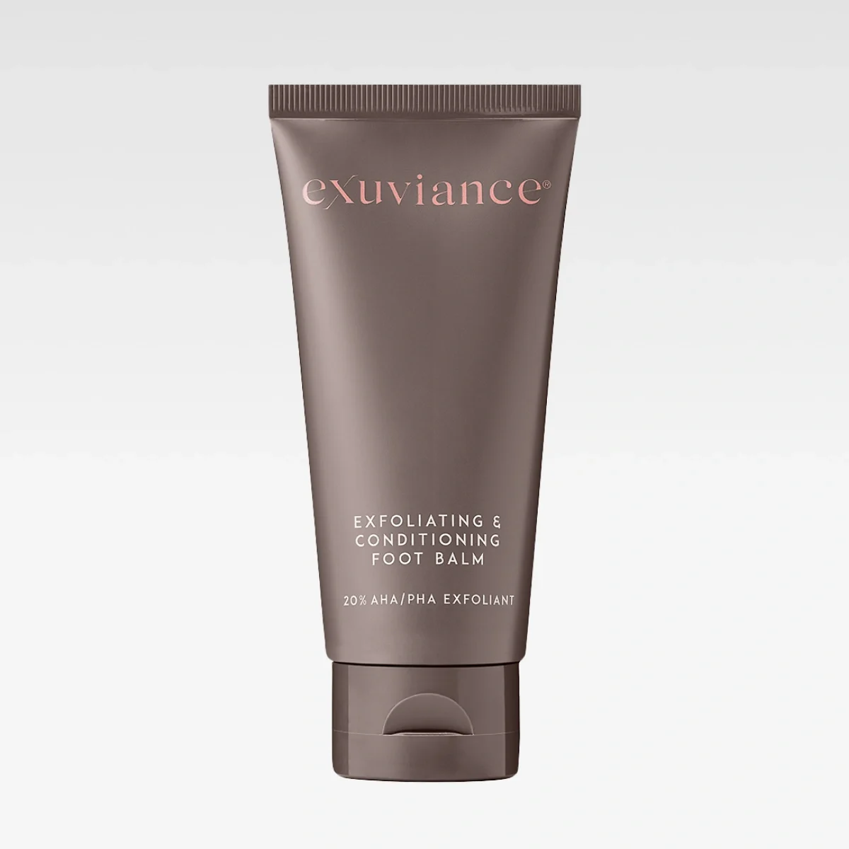 Ruskea tuubi Exuviancelta, jossa teksti “exuviance” ja “EXFOLIATING & CONDITIONING FOOT BALM”. Pakkauksessa lukee “20% AHA/PHA EXFOLIANT”.