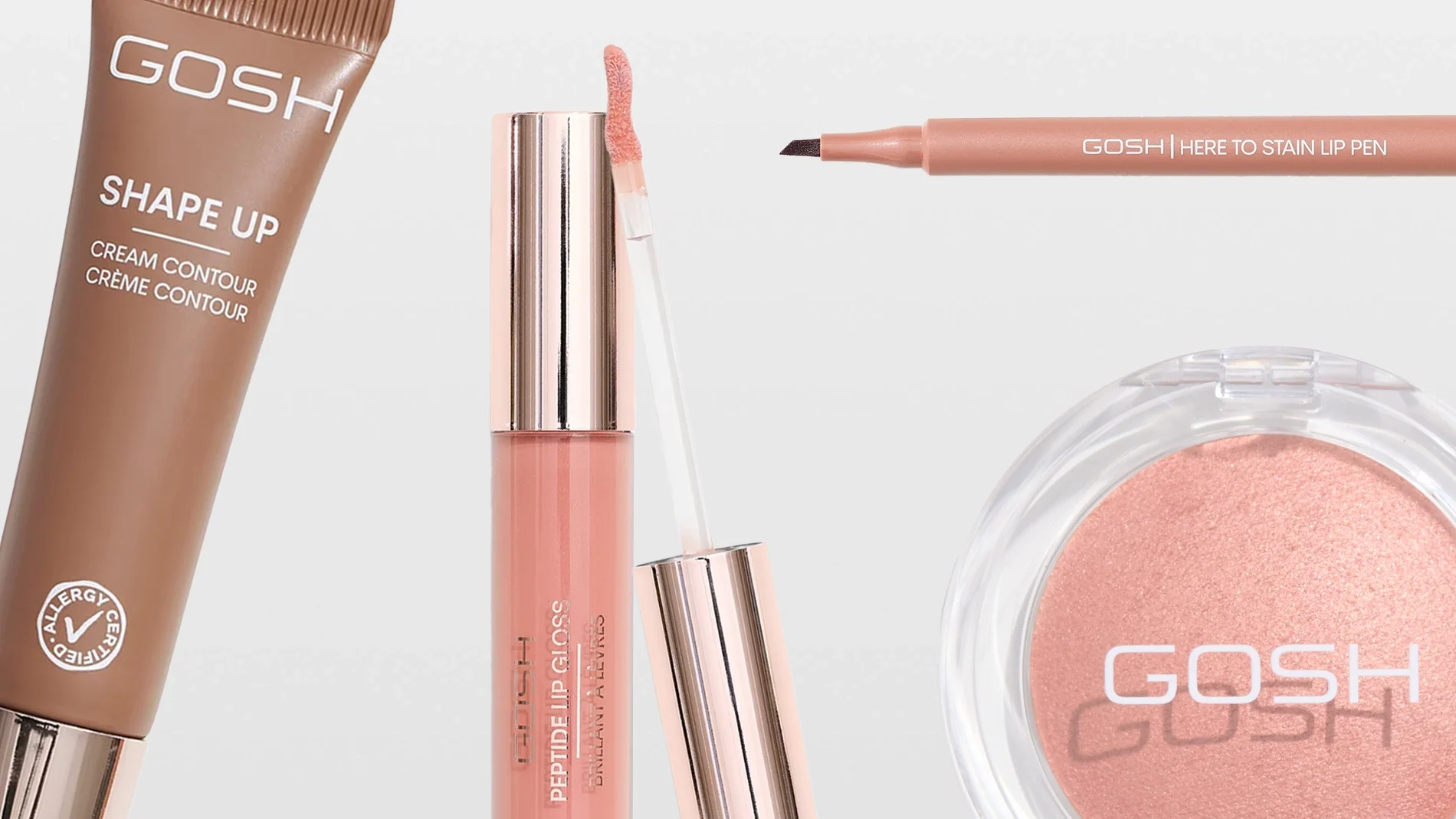Närbild på sminkprodukter från GOSH: Shape Up Cream Contour Crème Contour med Allergy Certified-symbol, Here To Stain Lip Pen, Peptide Lip Gloss Brilliant Lip Glaze med applikator samt ett runt puderrouge med GOSH-logotyp. Produkterna visas i nude- och rosatoner mot ljus bakgrund.
