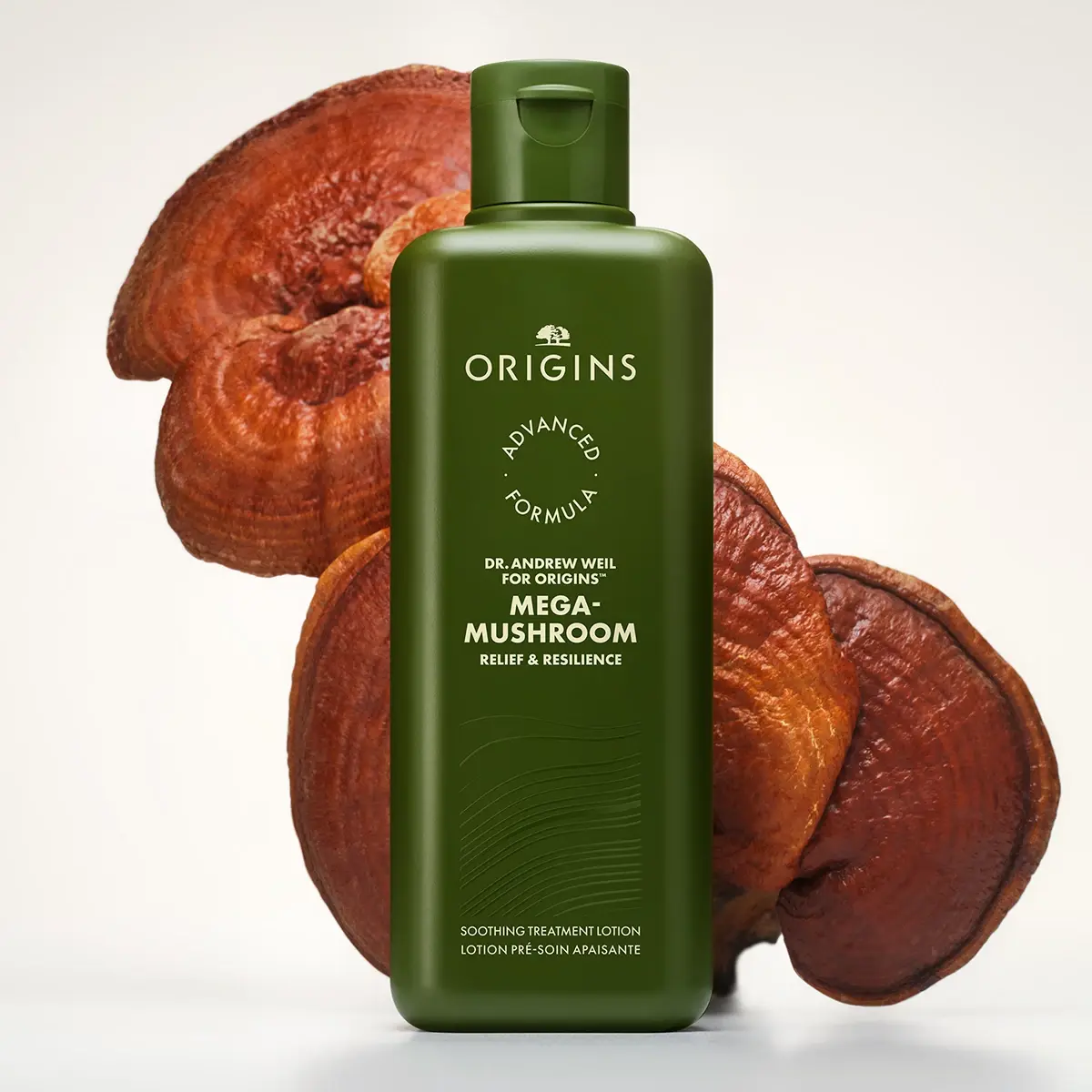 Origins Mega-Mushroom Soothing Treatment Lotion asetettuna suurten sienten eteen vaaleaa taustaa vasten.