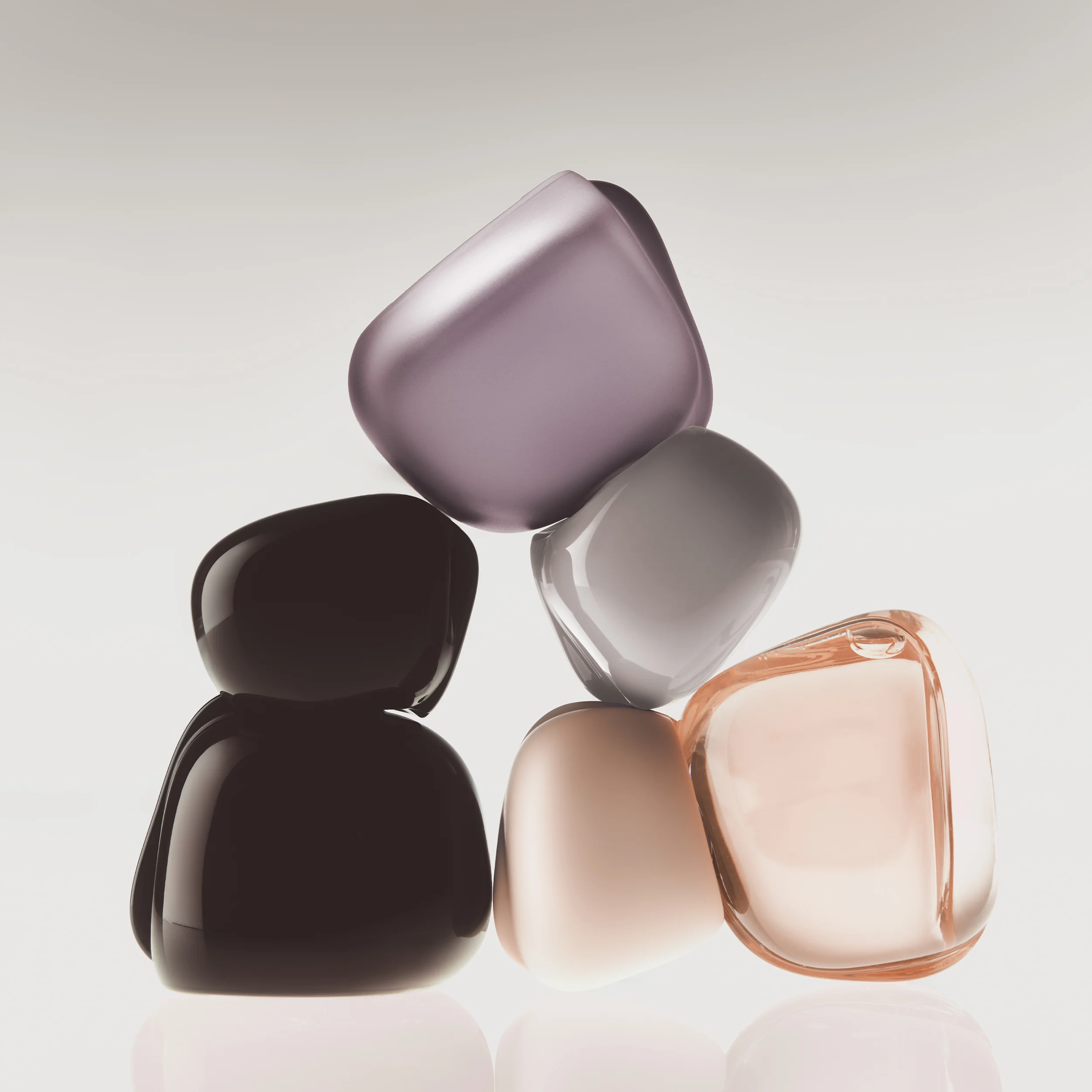 Tre Kylie Cosmetics Mood Stones-parfymeflasker mot en lys bakgrunn.