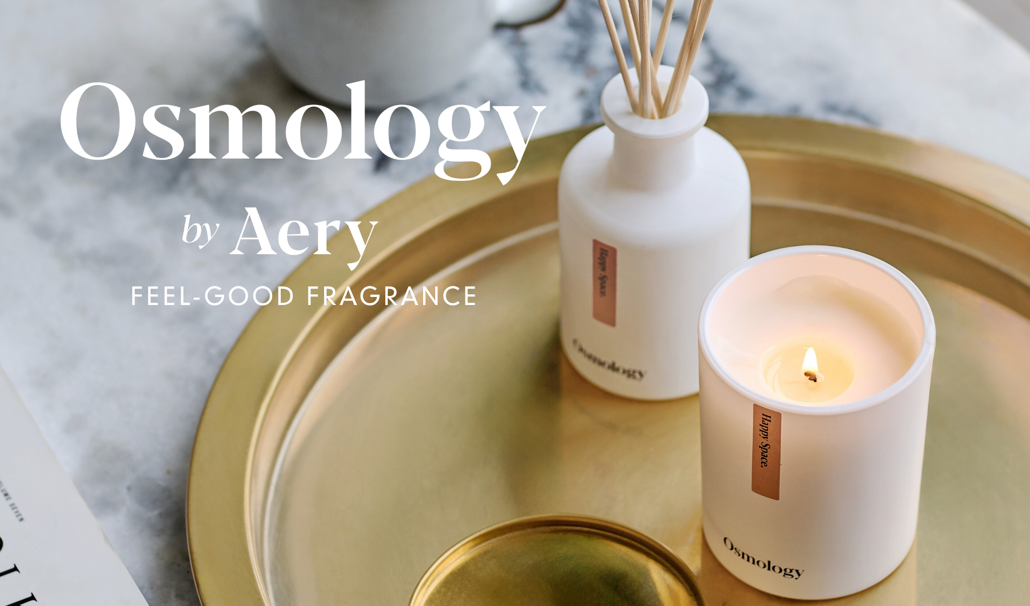 Osmology by Aery-duftlys og romduft på et gyllent brett. Bildet inneholder teksten «Osmology by Aery – Feel-Good Fragrance».