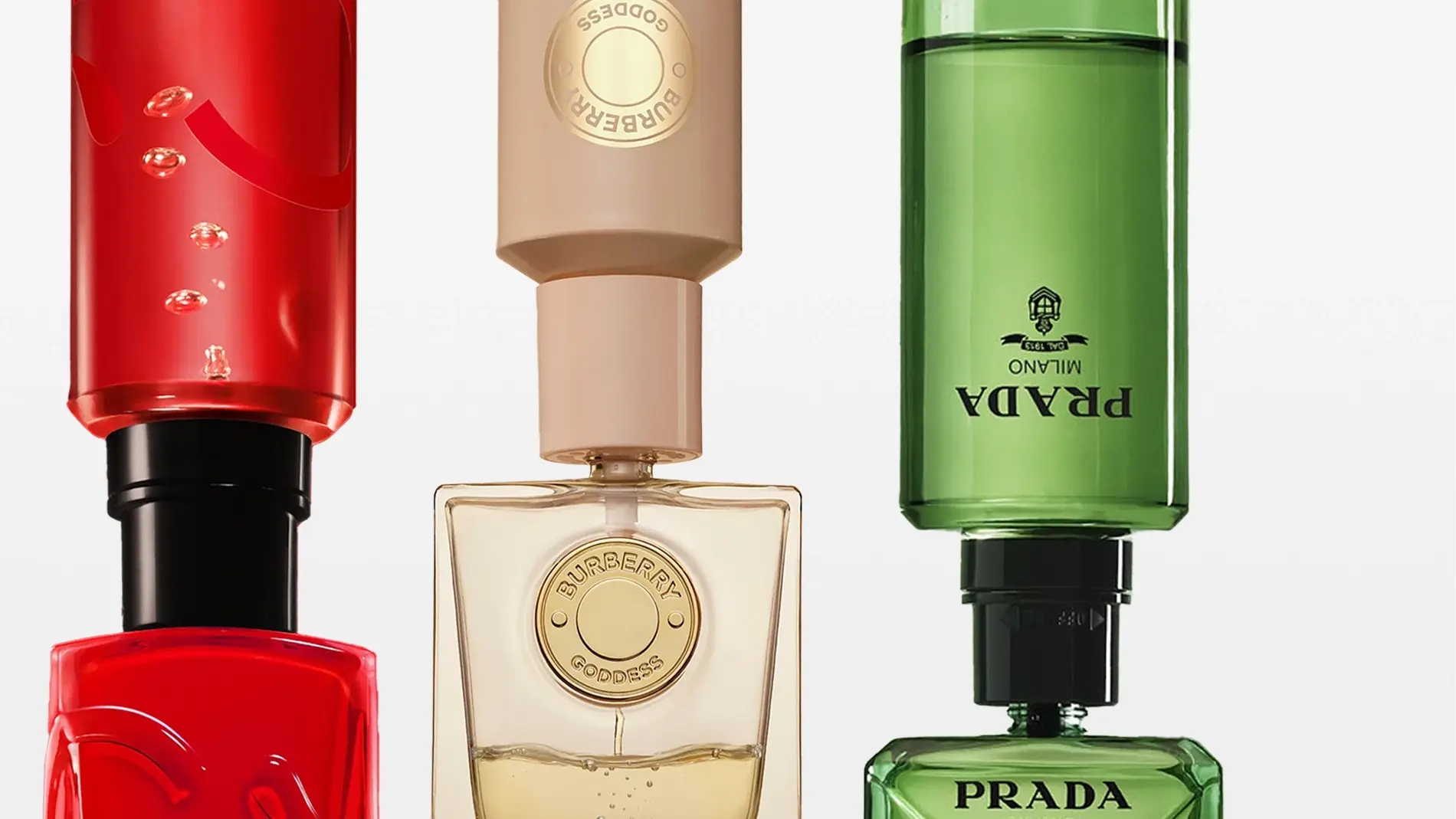 Kolme pinottua tuoksupulloa: punainen punaisella yläosalla, Burberry Goddess beigellä yläosalla, Prada vihreällä yläosalla.