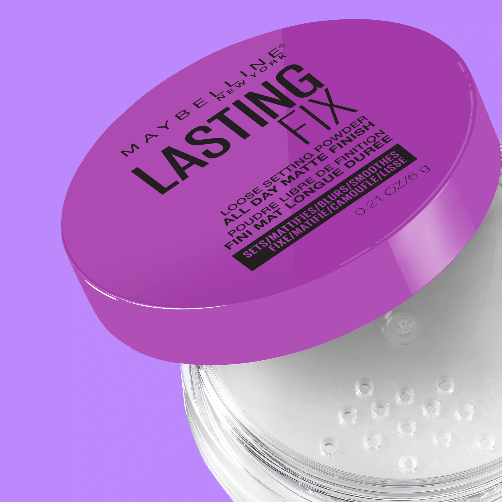 Lähikuva Maybelline Lasting Fix -irtopuuterista, jossa on violetti kansi ja läpinäkyvä purkki, violettia taustaa vasten.
