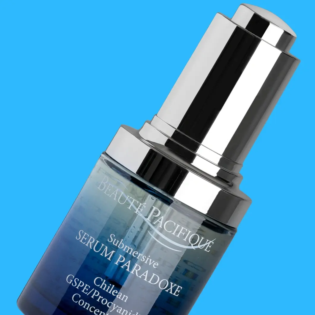 Beauté Pacifique Submersive Serum Paradoxe serumflaska, blå med silverfärgad pump.