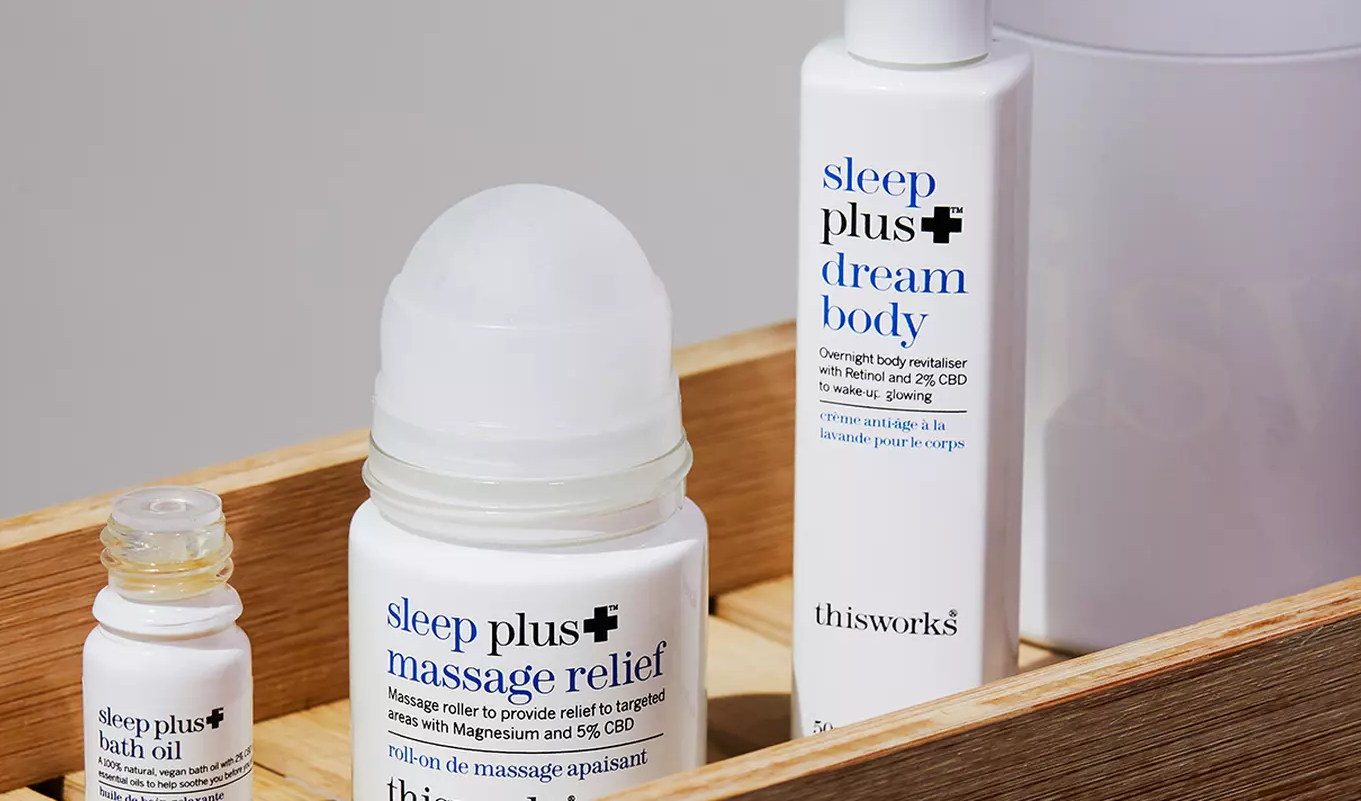 This Works-produkter på träbricka, inklusive Sleep Plus+ Bath Oil, Massage Relief och Dream Body.