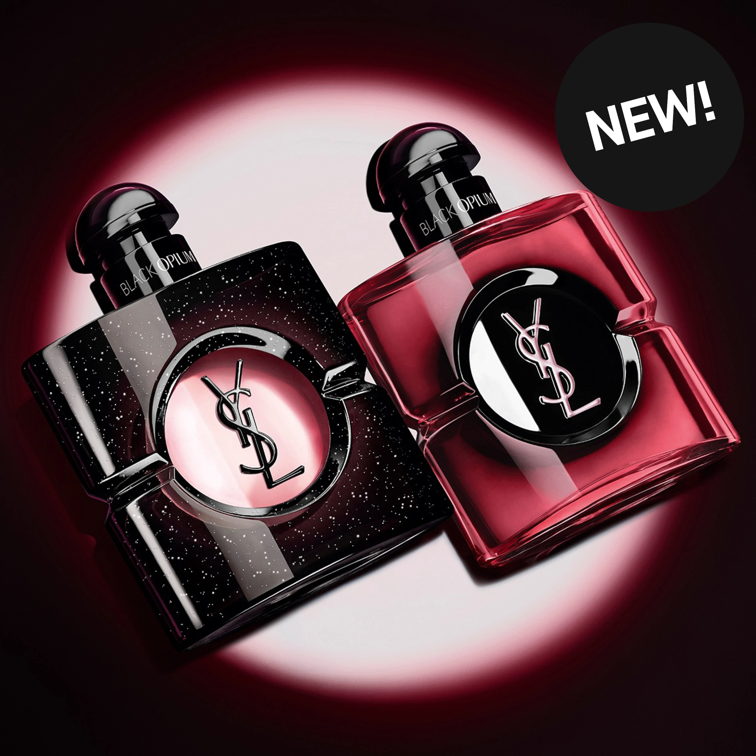 Två Yves Saint Laurent Black Opium-parfymer visas mot en mörk bakgrund med rosa ljuseffekt. Flaskorna har texten "BLACK OPIUM" och YSL-logotypen, och en svart cirkel med texten "NEW!" syns i det övre högra hörnet.