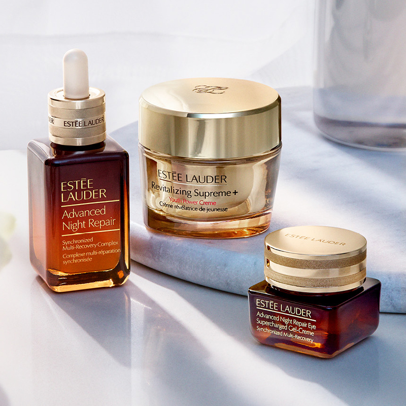 Tre hudpleieprodukter fra Estée Lauder plassert på en marmorflate mot en lys bakgrunn.
