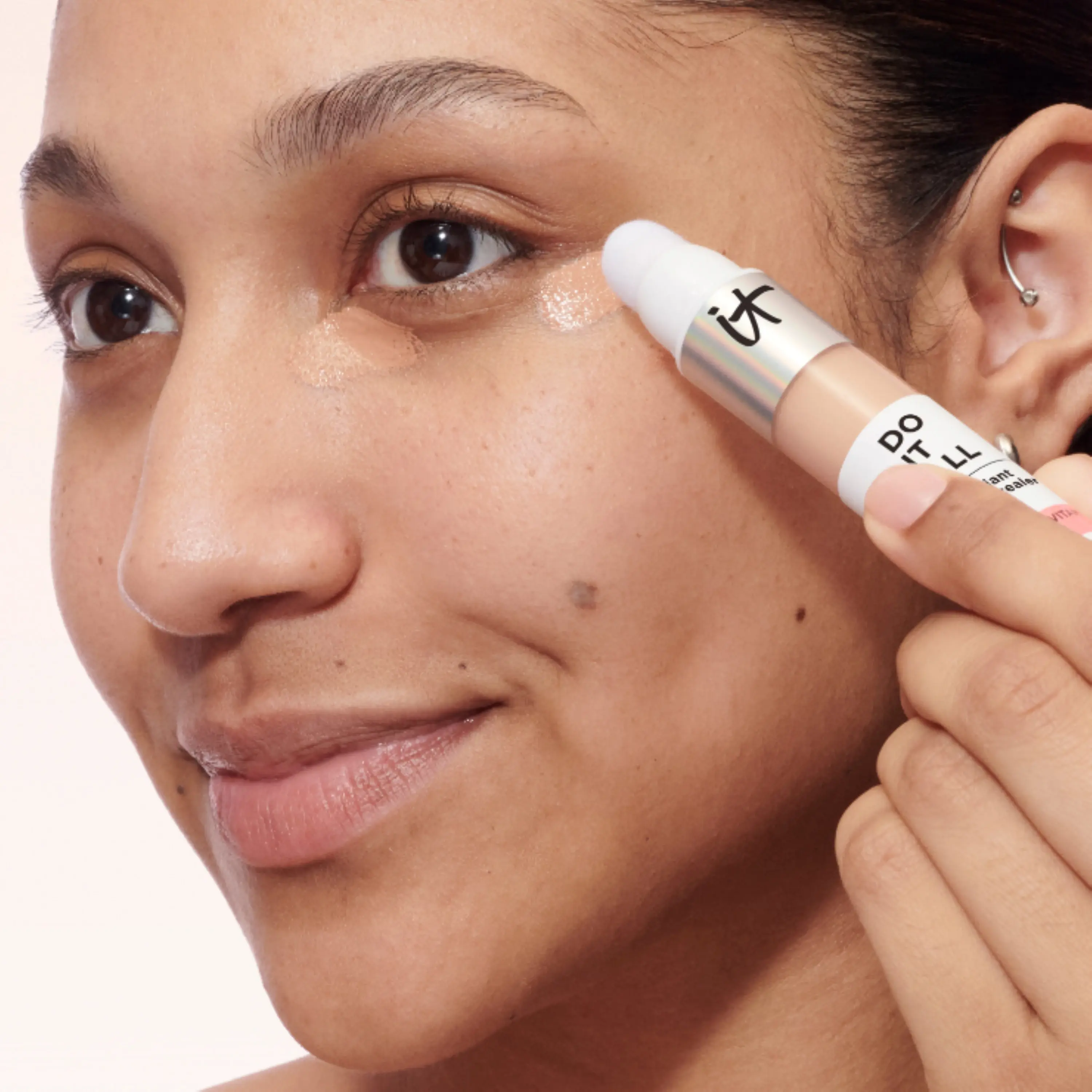 En person håller iT Cosmetics -concealer.