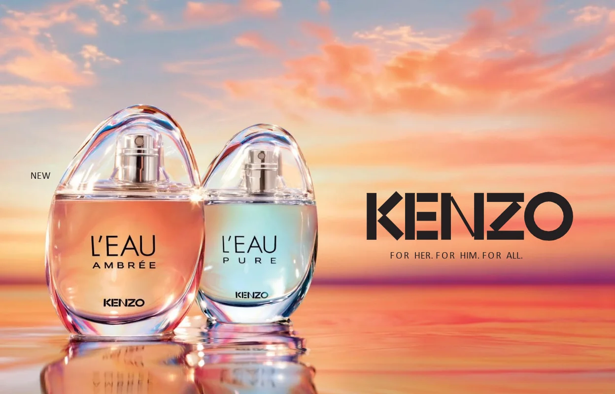 To Kenzo-parfymer, L’EAU AMBRÉE og L’EAU PURE, står på en speilblank vannflate foran en solnedgang i rosa, oransje og blå nyanser. Teksten «NEW», «KENZO» og «FOR HER. FOR HIM. FOR ALL.» vises sammen med produktnavnene på parfymeflaskene.