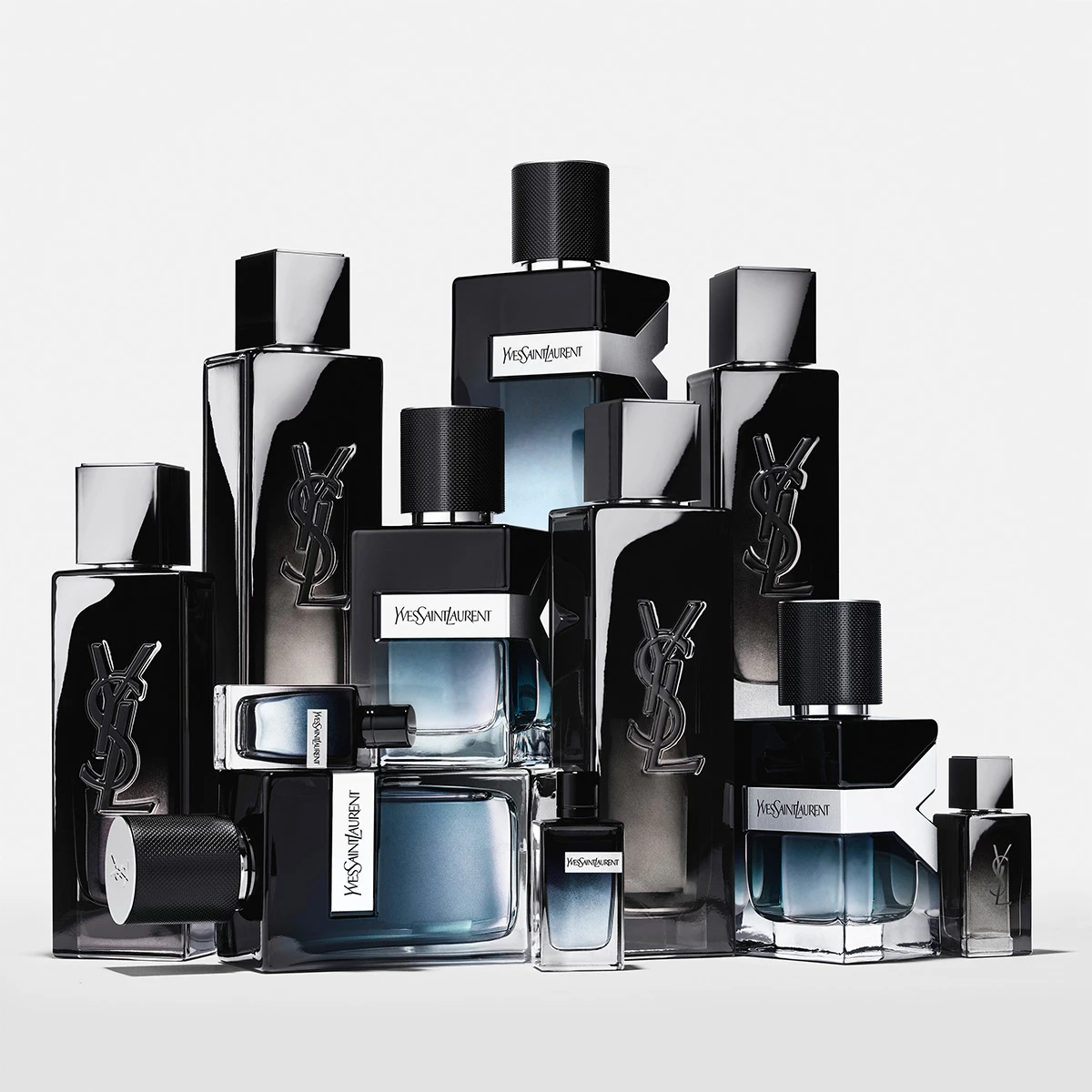 Yves Saint Laurent 'Y' herrparfymflaskor: mörkt glas, silverfärgade korkar och ljusblå vätska.