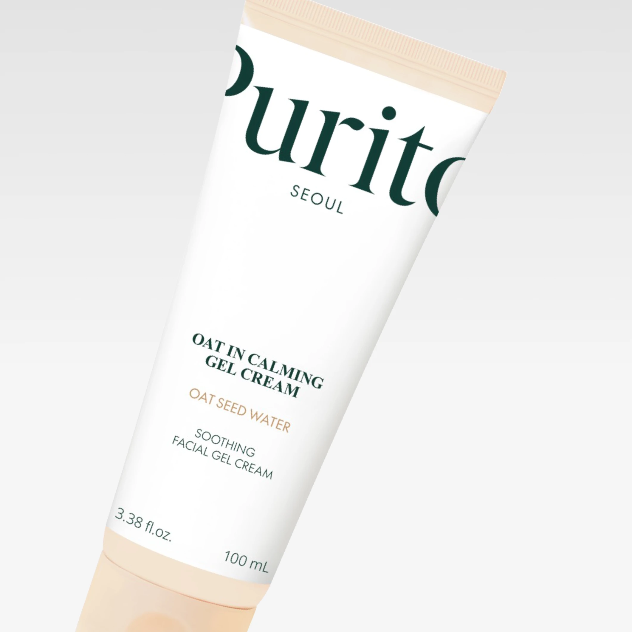 Purito Seoul Oat In Calming Gel Cream valkoisessa tuubissa beigenvärisillä yksityiskohdilla vaaleanharmaata taustaa vasten. Näkyvä teksti sisältää “Purito Seoul”, “OAT IN CALMING GEL CREAM”, “OAT SEED WATER” ja “SOOTHING FACIAL GEL CREAM”.