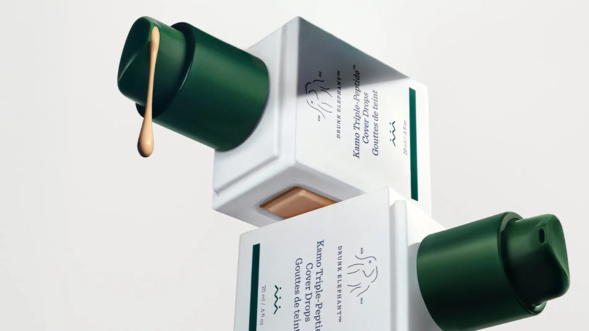 Drunk Elephant Kamo Triple-Peptide Cover Drops-flaska med mörkgrön pump. Ljus foundation droppar ut. 20 ml.