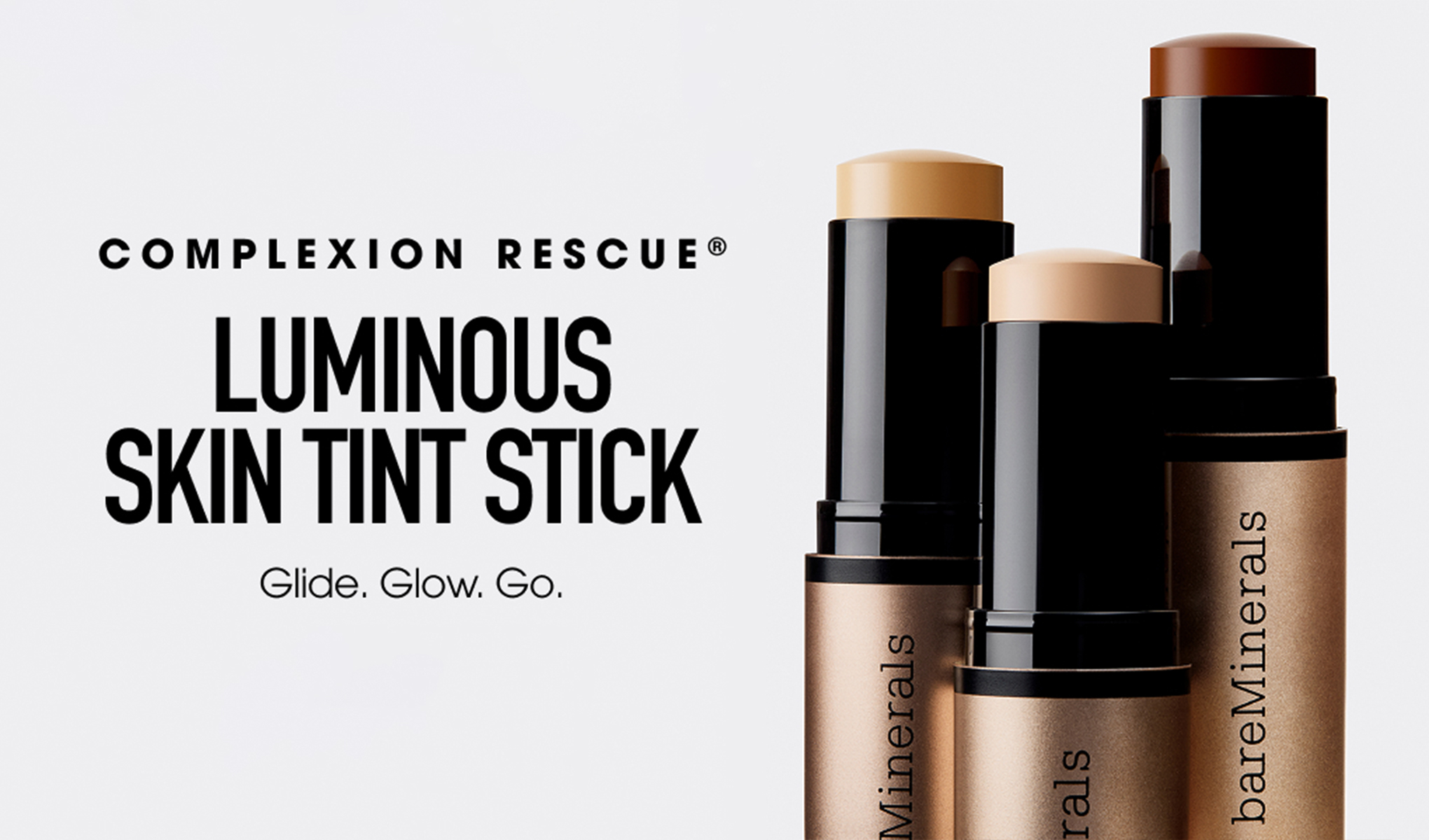 bareMinerals Complexion Rescue Luminous Skin Tint Stick vises i tre nyanser i stickformat med svart og bronsefarget emballasje. Teksten “COMPLEXION RESCUE”, “LUMINOUS SKIN TINT STICK” og “Glide. Glow. Go.” vises på en lys bakgrunn.