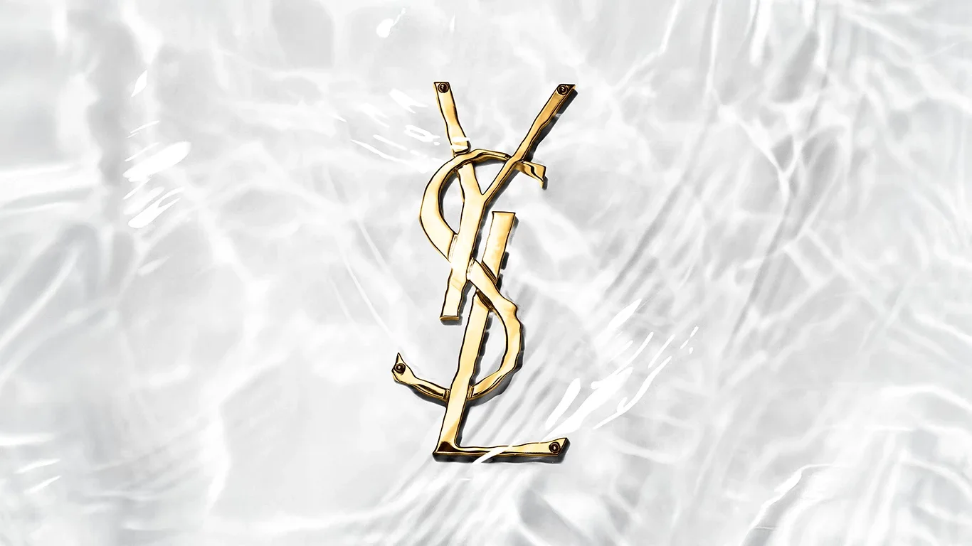 En gullfarget YSL logo under vann.