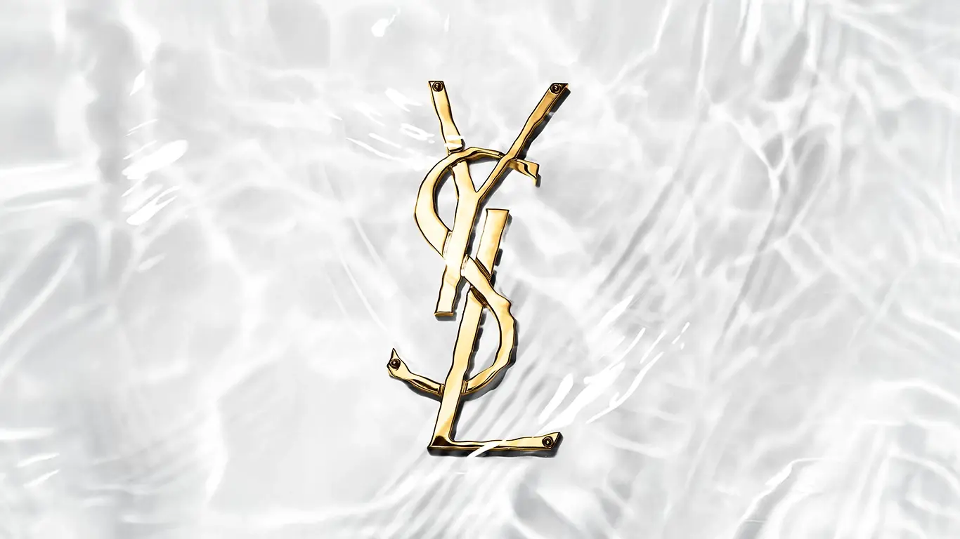 En guld-färgad YSL-logotyp under vatten.