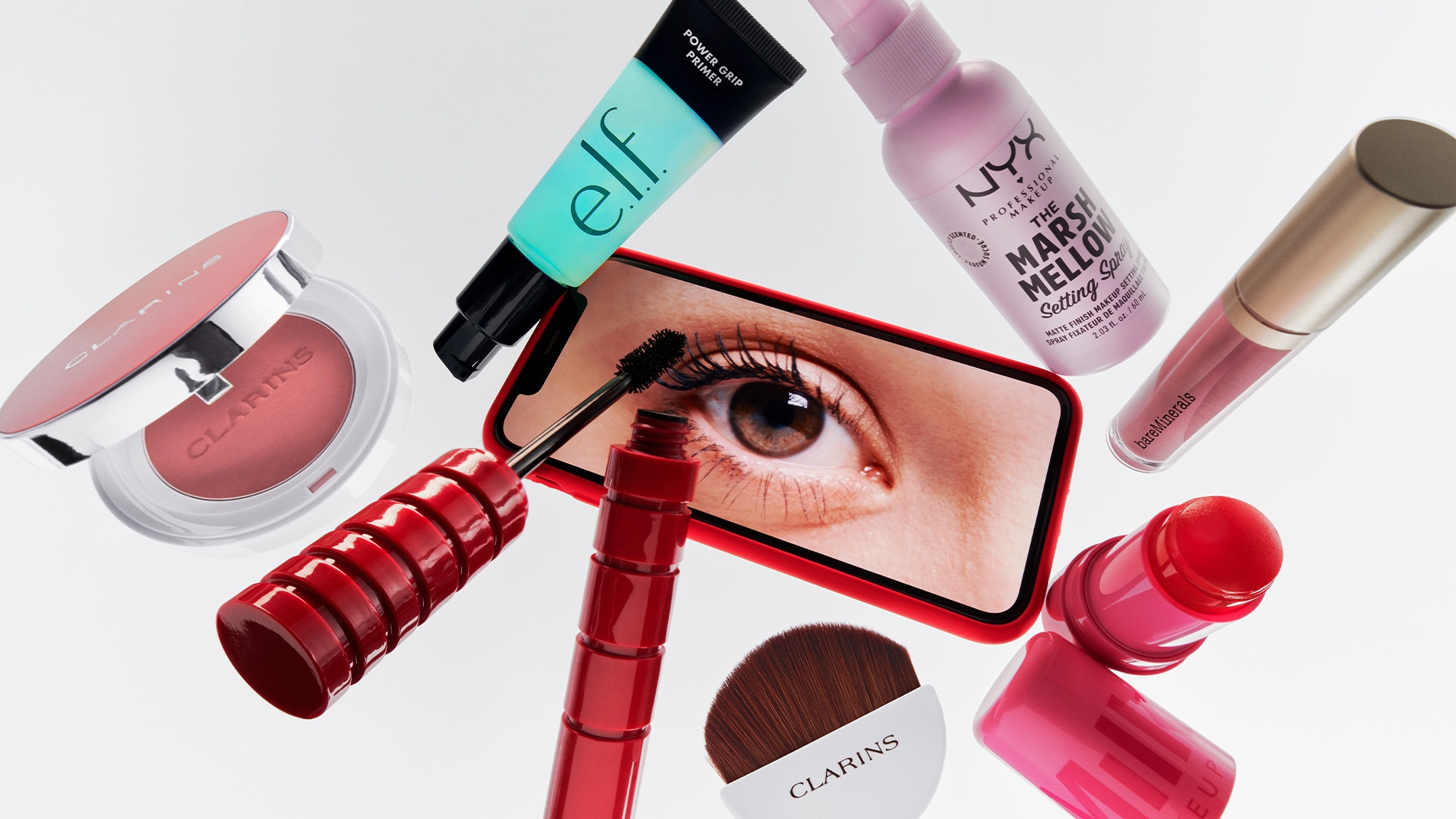 Kuva erilaisista meikkituotteista, mukaan lukien huulipuna ja ripsiväri, valkoista taustaa vasten.